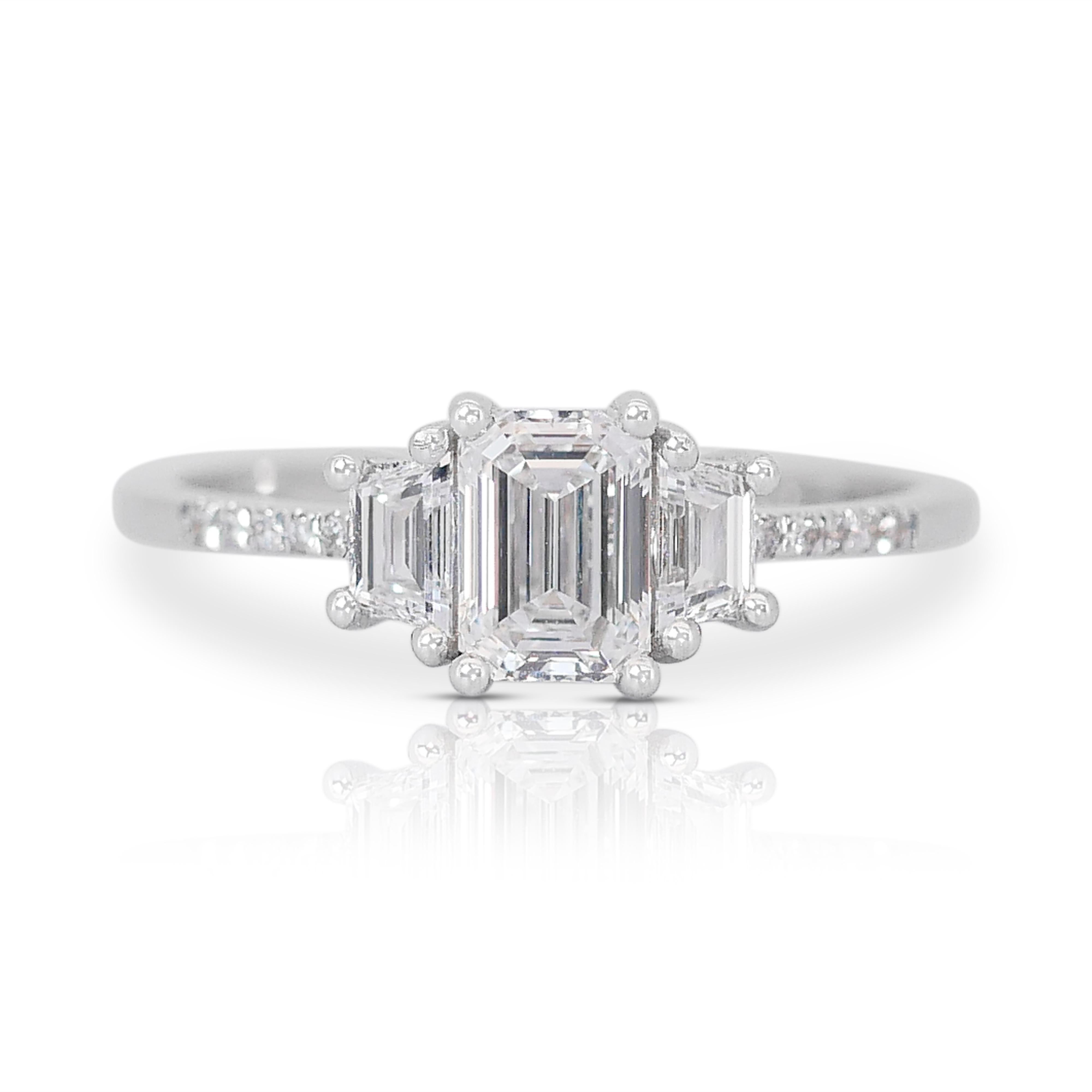 Lustrous 1.22ct Emerald-Cut Diamond 3-Stone Ring in 18K White Gold - GIA Certified (en anglais)

Réalisée en or blanc 18k, cette luxueuse bague à 3 pierres en diamant met en valeur un diamant taille émeraude de 0,91 carat en son centre, symbole