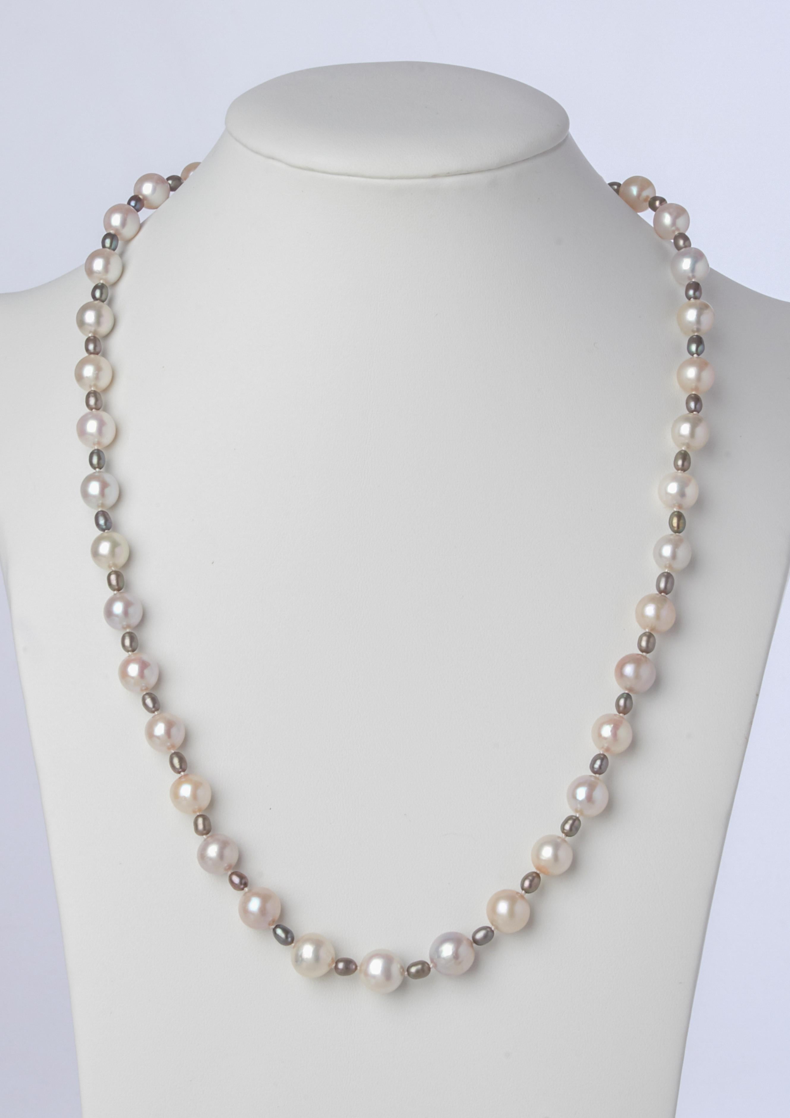 Stylish with the versatility of a soft neutral hues, this  hand-strung twenty two inch necklace is crafted of thirty eight white lustrous 8-3/4mm Akoya pearls, accented with petite gray off round pearls. The strand is finished with a sterling silver