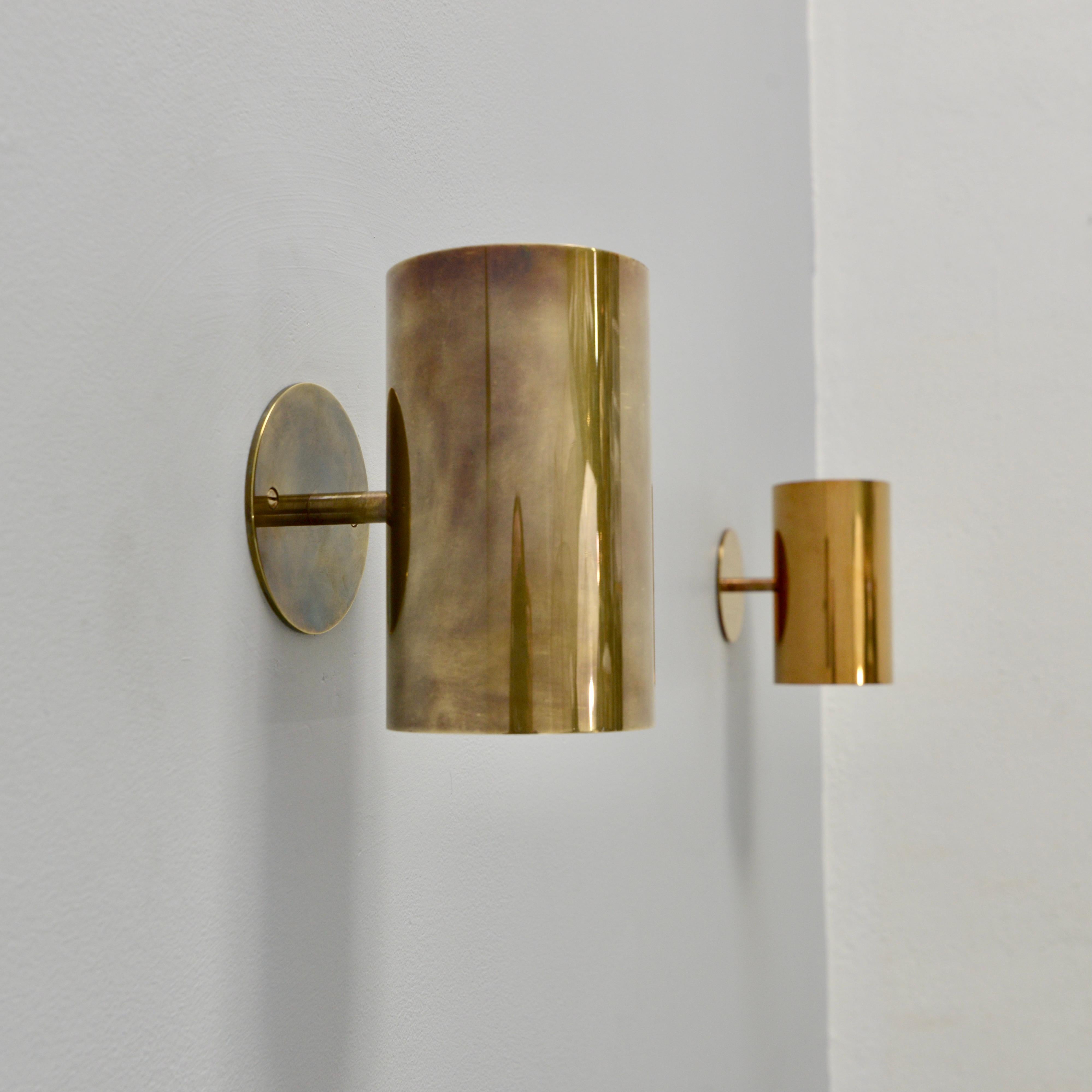 The stunning LUte sconce by Lumfardo Luminaires is an up and down fixed cylindrical wall sconce in unlacquered patinated brass or unlacquered gold finish. An all brass fixture, with illumination emitting from the top and from the bottom of the