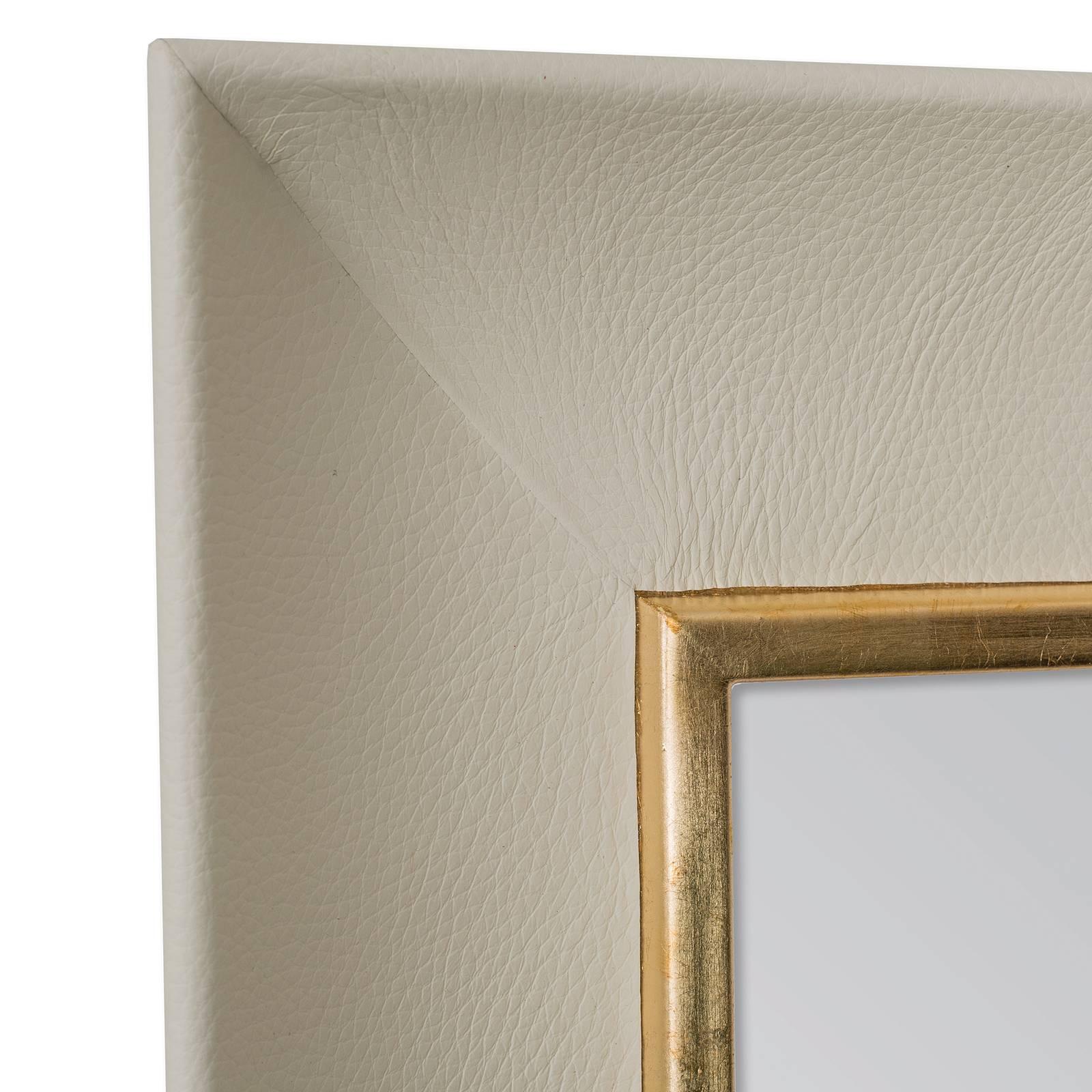 Combining the different textures of metal and leather, this mirror is a stunning modern accent to a living room, bedroom, or entryway. Its minimalist frame is dressed in fine and soft genuine grain leather in a off white color (also available in