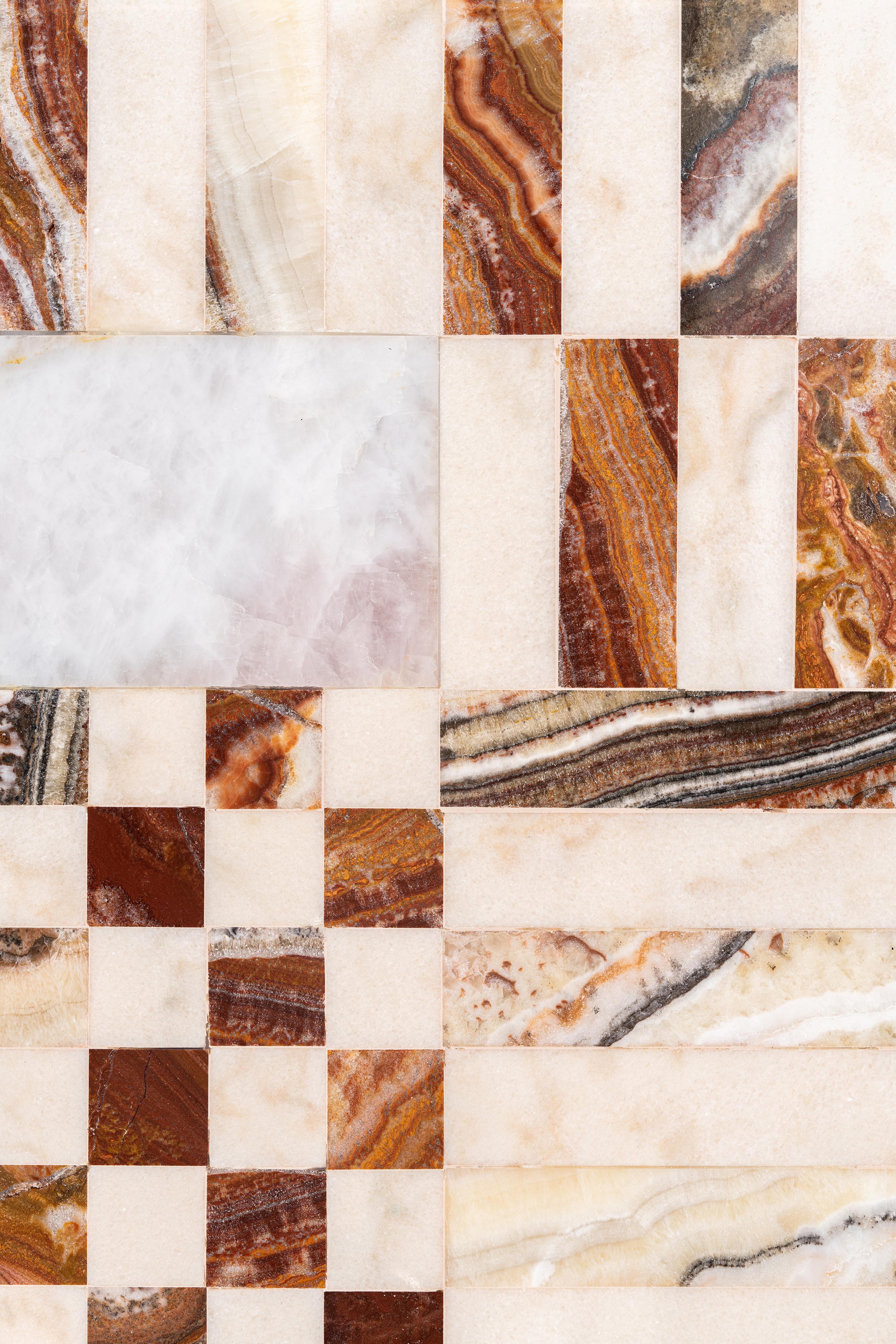 Une superposition ludique et graphique de motifs en marbre qui illustre parfaitement l'esthétique d'ALTIS. Les teintes des blushes et des bourgognes se reflètent parmi les marbres, le coton tissé à la main et le cuivre qui constituent l'union