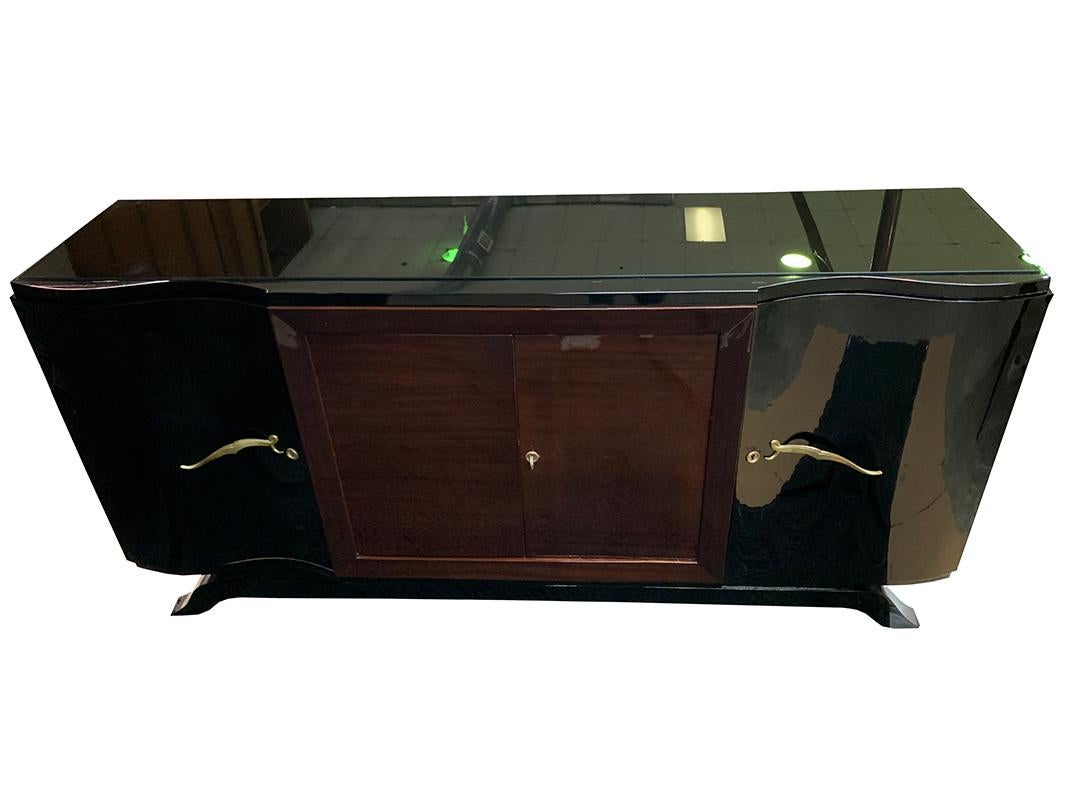 Luxe Art Deco sideboard / credenza / buffet featuring a solid Mahogany frame with centre doors and sides veneered in Rosewood, side doors, top and base in black piano lacquer. The piece has two single doors with stylish brass handles and one centre