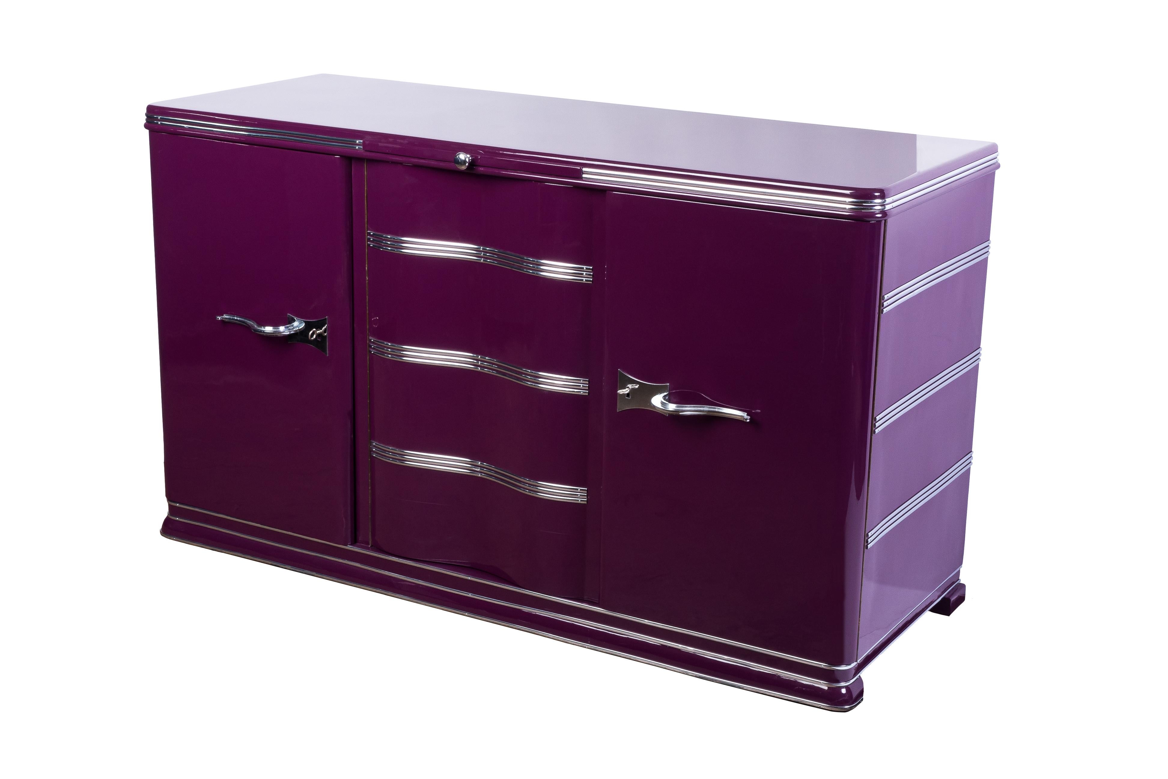 Luxe Art Deco sideboard features (3) exterior swing doors with (2) oak drawers and a shelf in the left compartment and one shelf for storage on the large compartment. It has been finished in a beautiful high gloss Lilac lacquer with chrome detailing