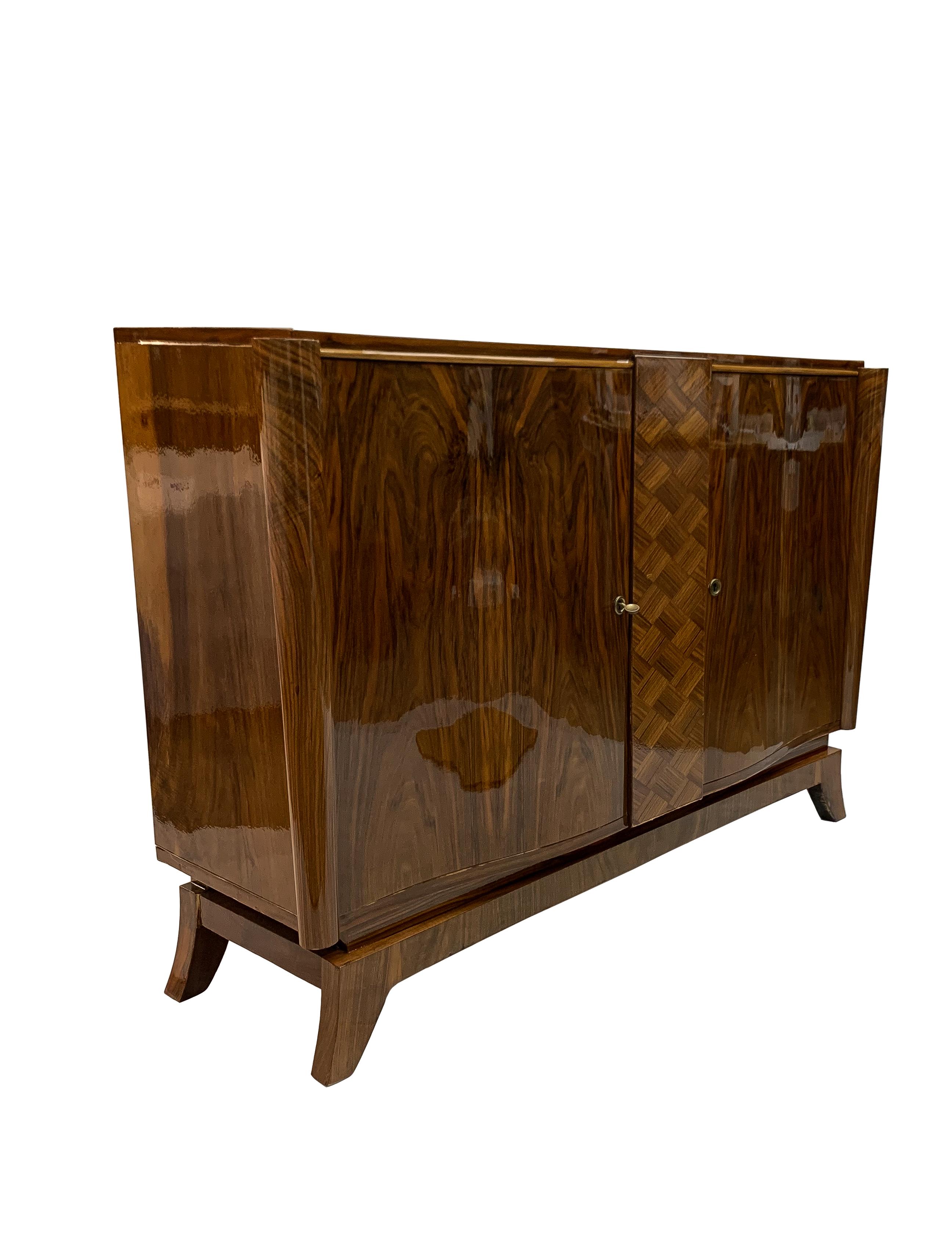 Luxe Art Deco sideboard/ buffet / credenza in solid mahogany and veneered in luxurious Walnut with stylized legs. The two doors in beautifully bookedmatched veneer and center panel in marquetry. One shelf for storage.

Made in France circa