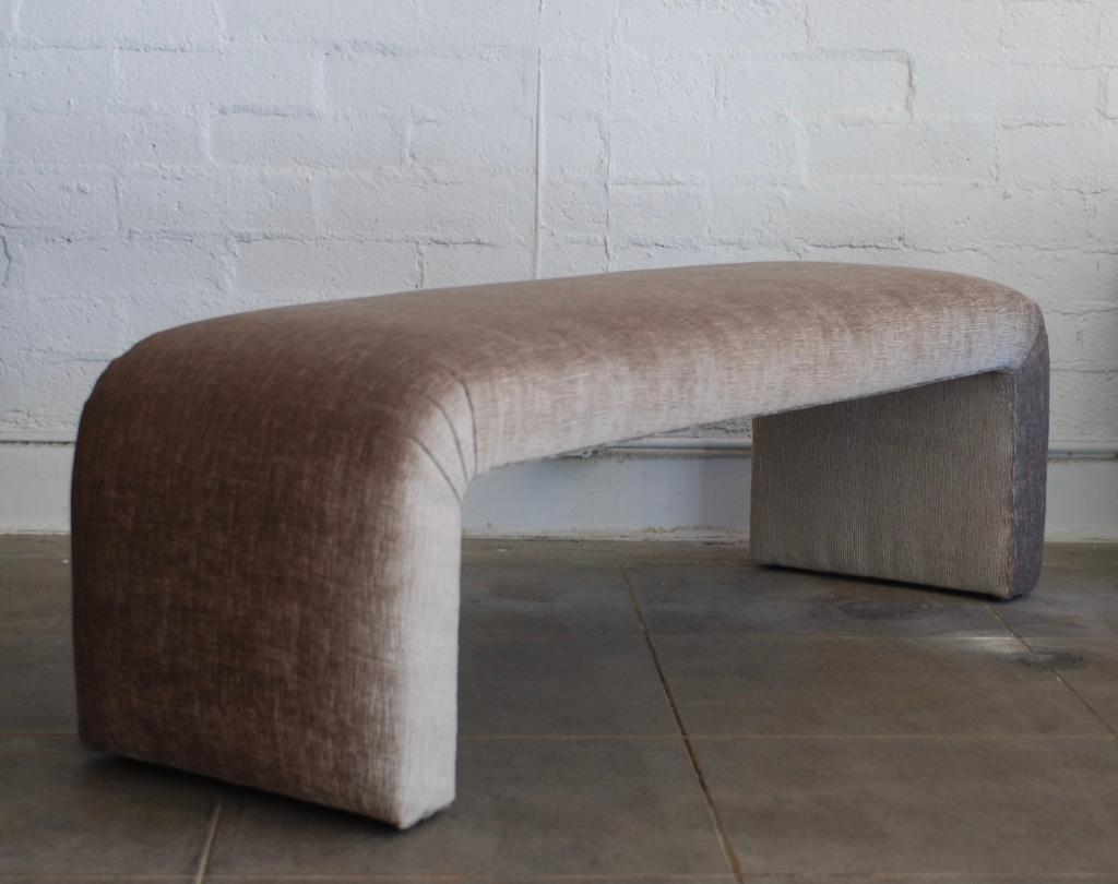 This vintage reupholstered bench has been recovered in a luxurious taupe velvet that has a fine charcoal black wavy line pattern throughout. The fabric is very soft to the touch and has a slight sheen to it. 

