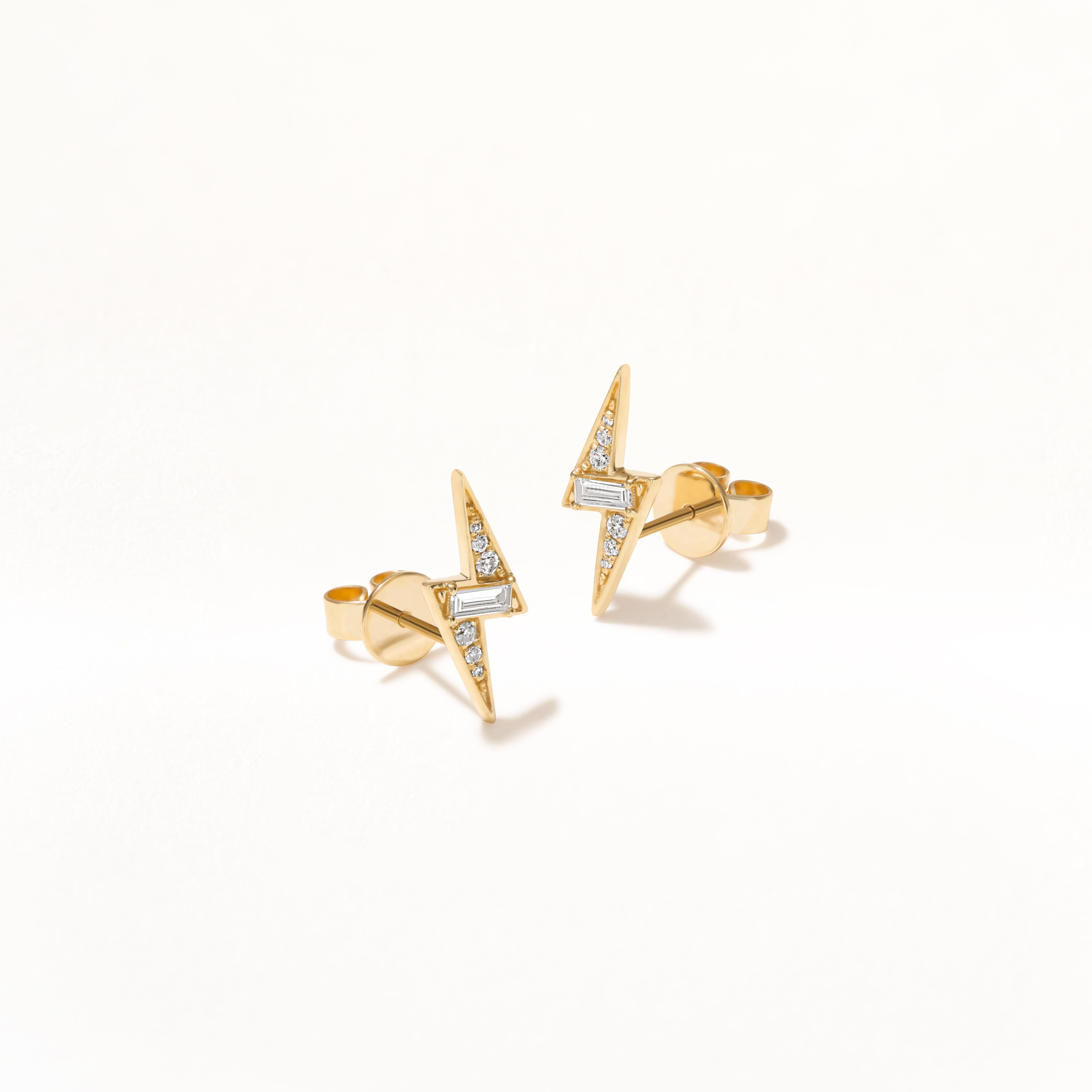 Ces boucles d'oreilles Luxle en or jaune 14 carats, ornées de diamants, présentent un design captivant. Cet audacieux pendentif en forme d'éclair est complété par un subtil scintillement de diamants baguettes au centre, flanqués d'une paire de