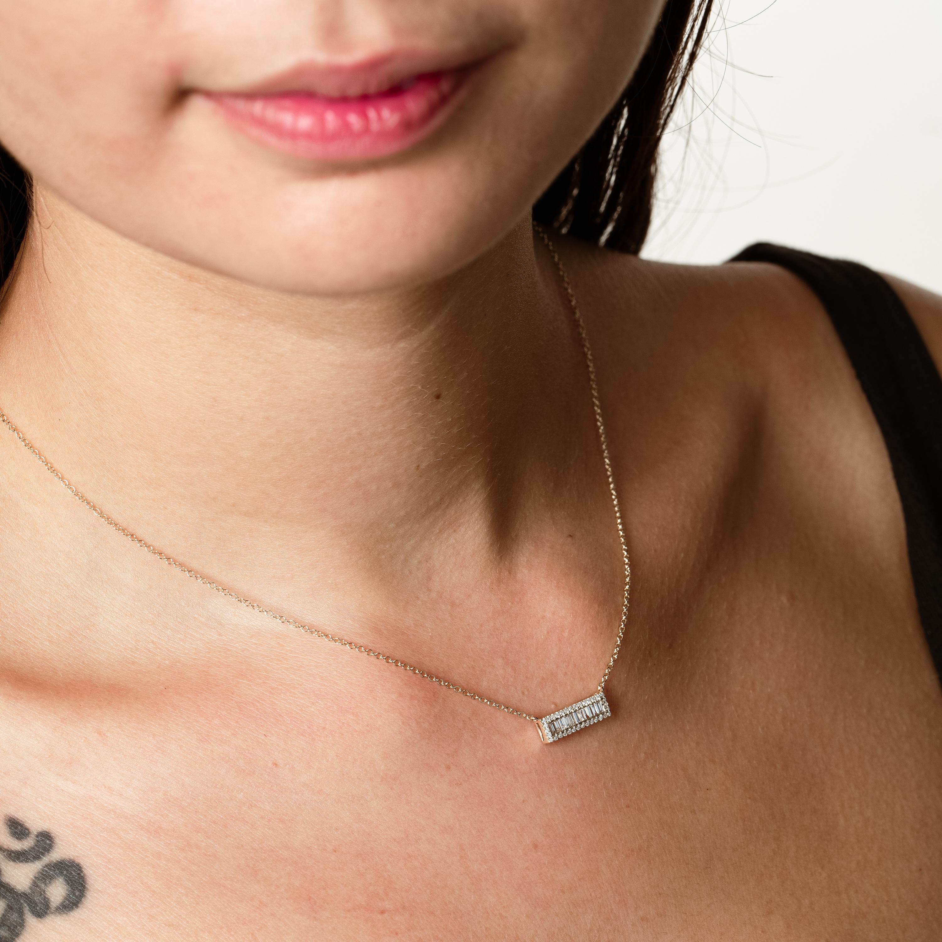 Questa elegante collana a barretta in oro bianco 18 carati presenta una straordinaria combinazione di diamanti rotondi e a taglio baguette, meticolosamente disposti all'interno di un elegante pendente rettangolare. I diamanti baguette, noti per le