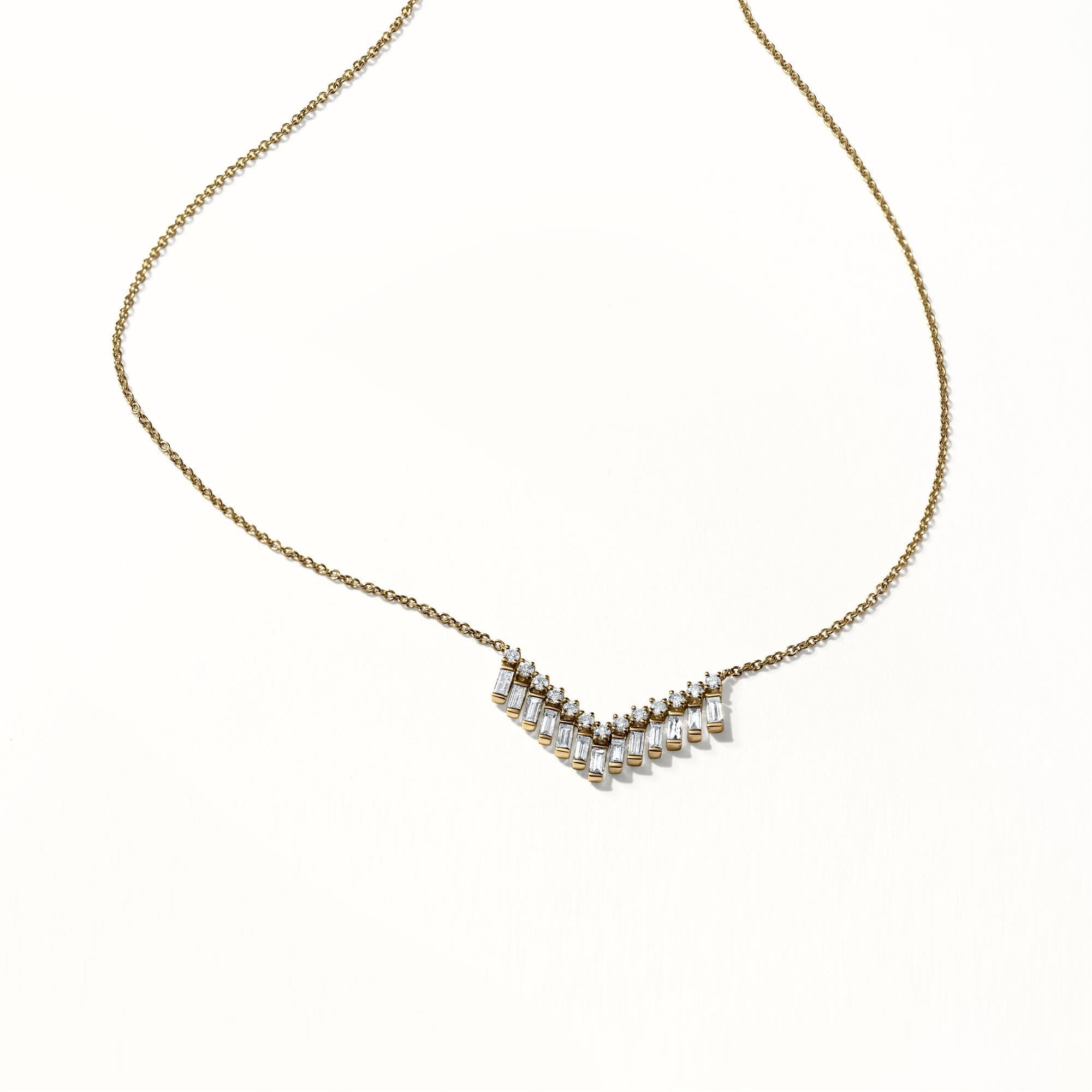 Cet élégant collier à chevrons en diamants présente un design en forme de V en cascade qui ajoute une touche de sophistication moderne. Le pendentif est orné d'une combinaison de diamants ronds et baguettes, créant un effet brillant et allongé. Les