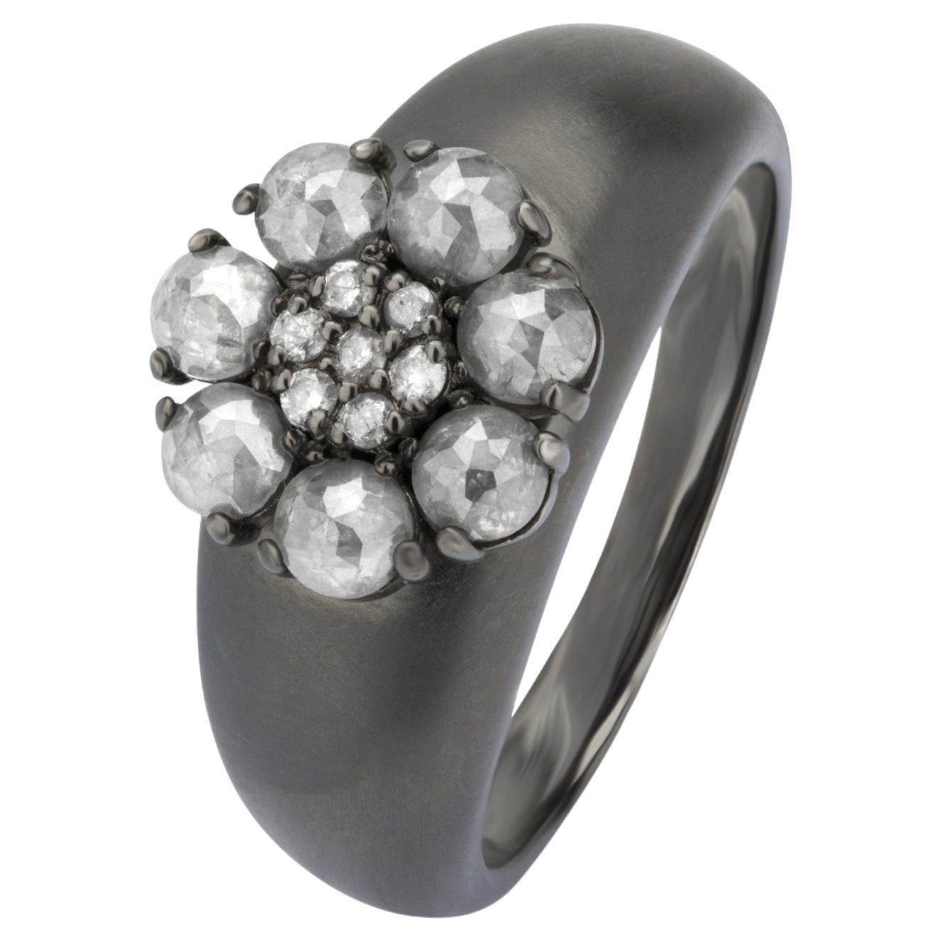 Cette remarquable bague en or 14K rhodié noir présente un captivant design floral composé de diamants ronds méticuleusement disposés, chacun étant serti sur des griffes pour en rehausser l'éclat. La grappe centrale de diamants est entourée d'un halo