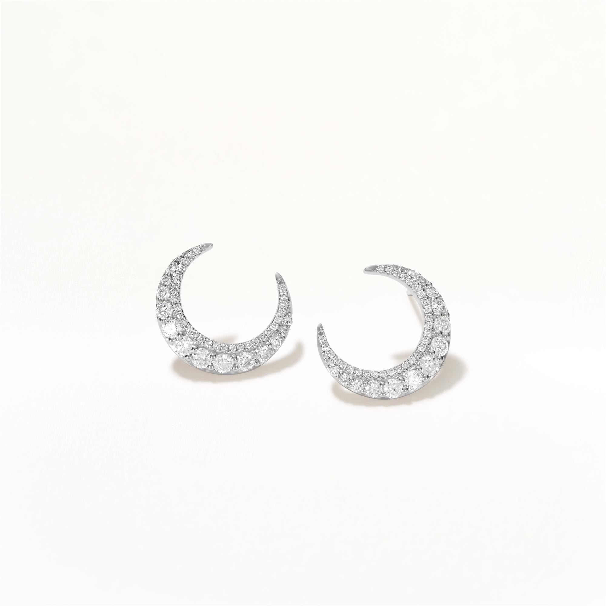 Embrace celestial elegance with the Luxle Crescent Moon Earrings, a sophisticated and whimsical addition to any jewelry collection. Crafted in sleek 18K white gold, these earrings feature a delicate crescent moon design adorned with shimmering round