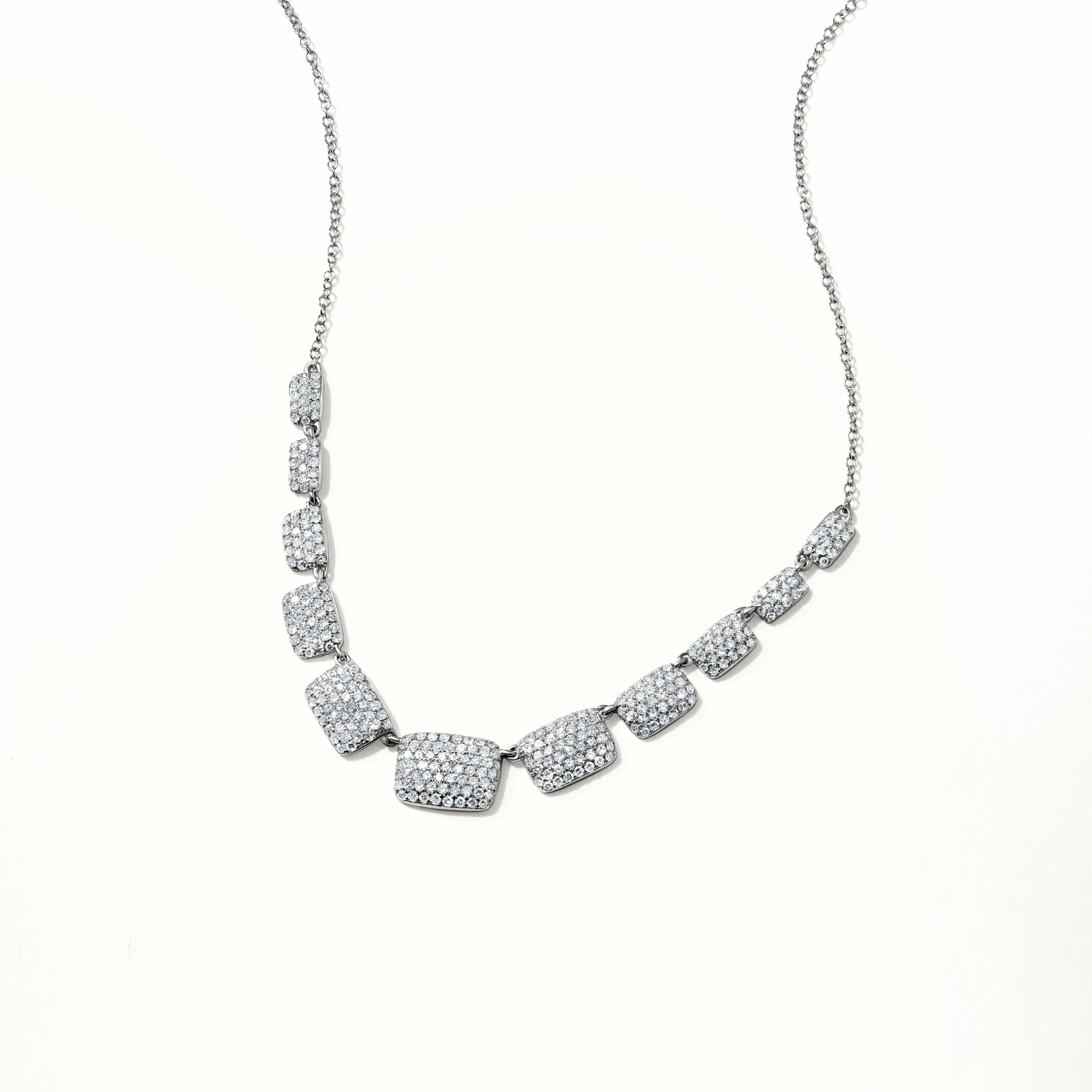 Indulge in elegance with this exquisite necklace, featuring a delicate chain complemented by nine symmetrically arranged, rectangular diamond-encrusted links. Each link, shimmering with multiple small diamonds, gracefully decreases in size from the