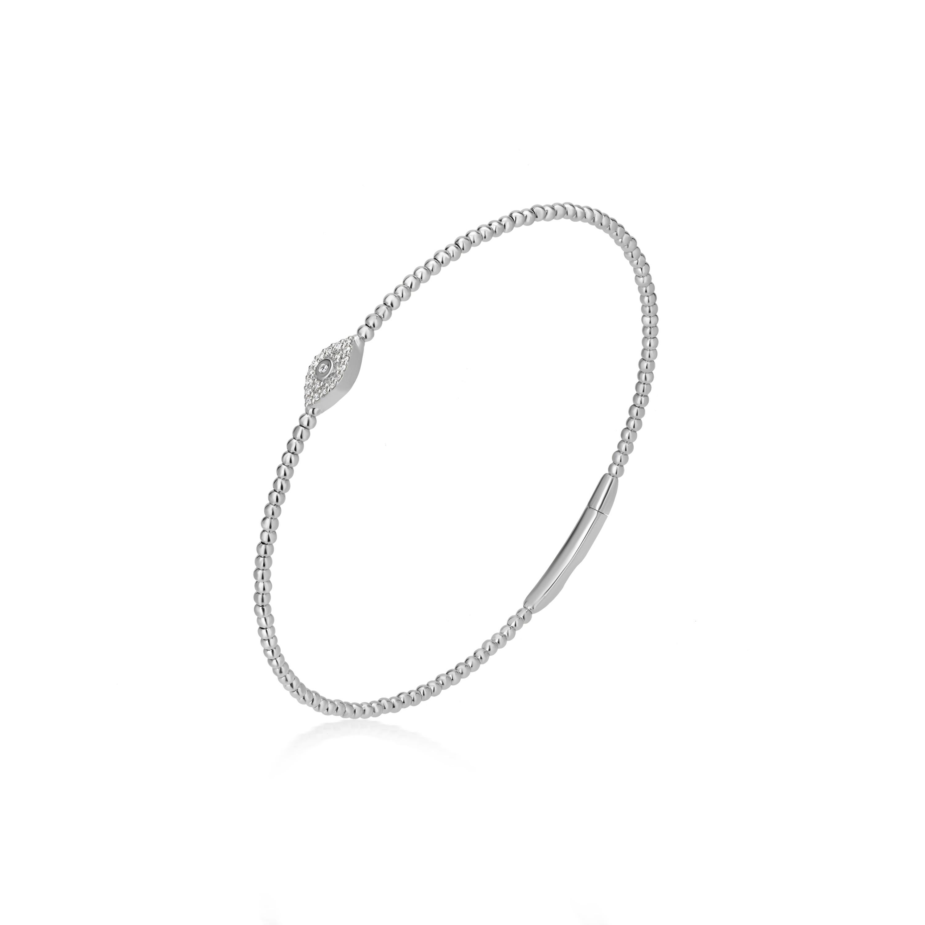 This Luxle bangle bracelet is a stunning piece of jewelry that is sure to turn heads. The centerpiece of the bangle is a cluster of diamonds in the shape of an eye, with each diamond expertly pave set to create a sparkling effect. The band of the