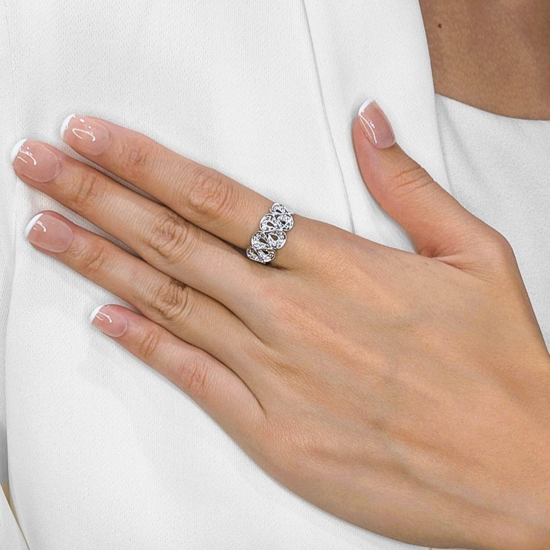 This exquisite new ring exudes graceful sophistication with its artistic filigree design in polished 18K white gold. Adorned with 49 round brilliant diamonds totaling 0.19ct in F-G color and VS-SI clarity, the piece sparkles with delicate radiance