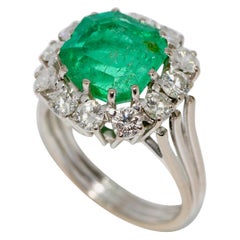 Luxueuse bague en or blanc 18 carats avec une grande émeraude et 12 diamants