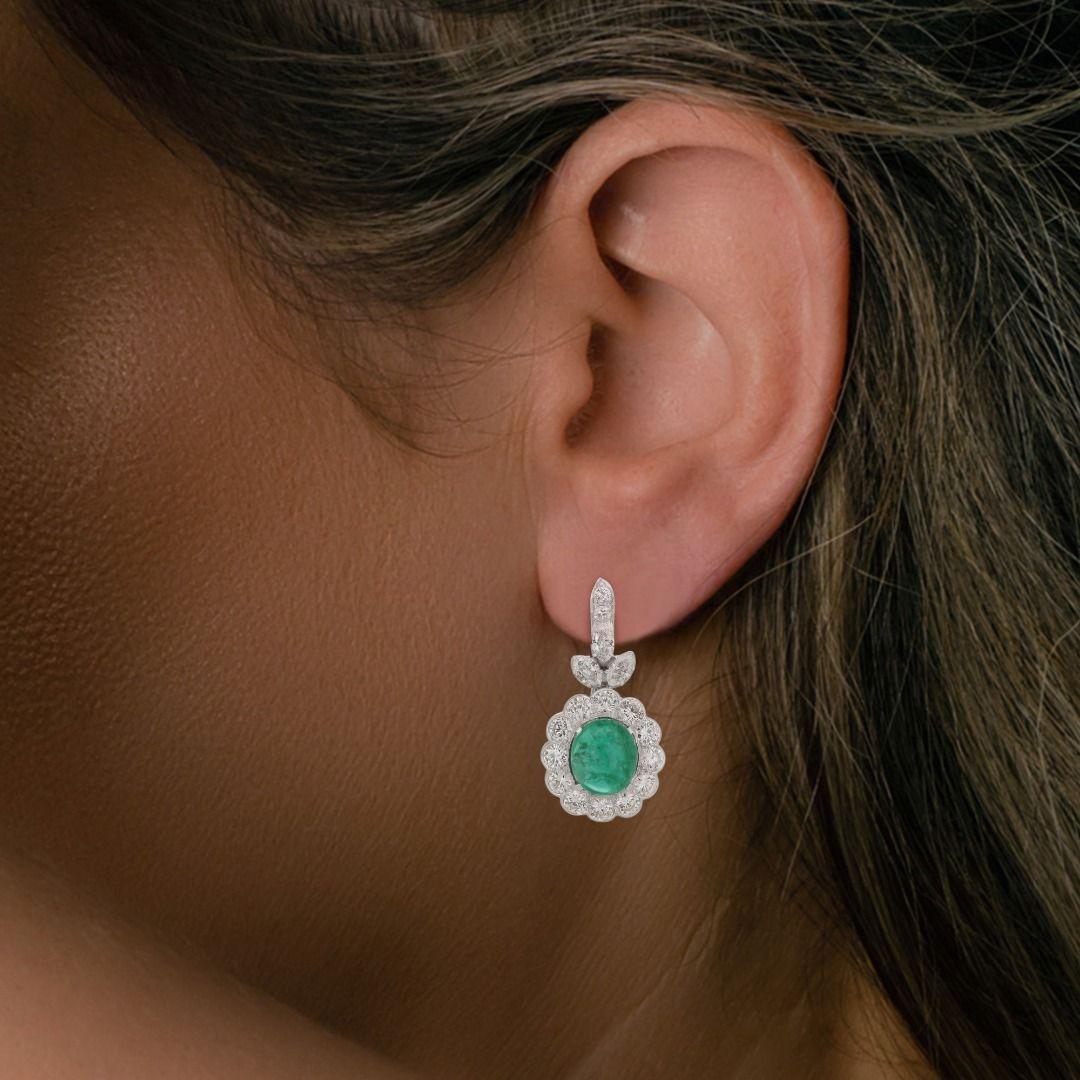 This magnificent piece, crafted in 18K white gold, is an exquisite fusion of luxury and craftsmanship. It showcases two spectacular emerald stones as the centerpiece, collectively weighing an impressive 10.00ct. These emeralds are cut in a round