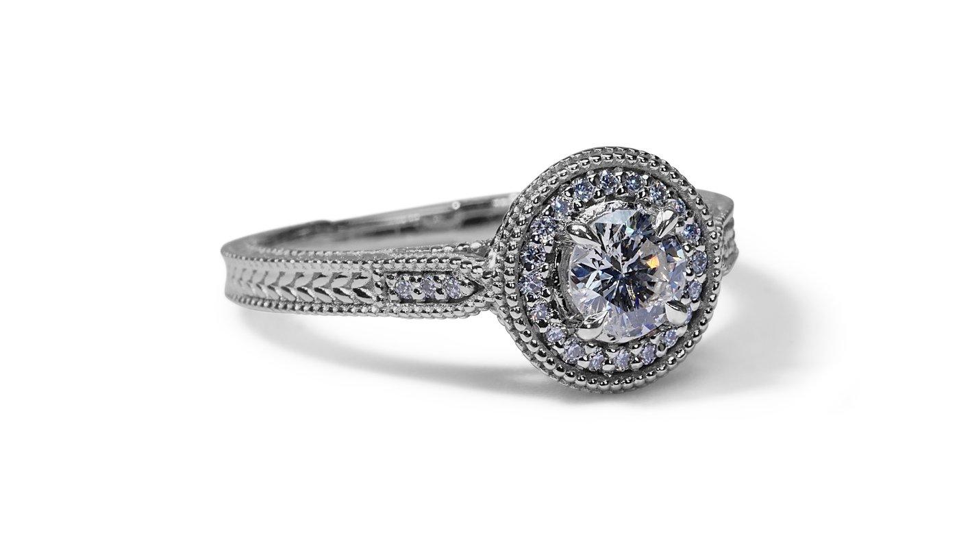 A classic halo ring with a dazzling 0.44-carat round brilliant natural diamond. It has 0.15 carat of side diamonds which add more to its elegance. The jewelry is made of 18K White Gold with a high-quality polish. It comes with an AIG certificate and