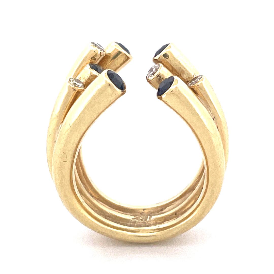 Luxurious 18k Yellow Gold Diamond and Sapphire Split Open End Cuff Ring

Indulge in the opulence of this exquisite 18k yellow gold cuff ring, showcasing a mesmerizing split open end design. The ring is composed of five gold tubes seamlessly merged