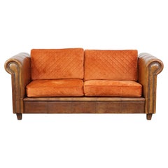 Luxurious 2.5-seater sheepskin sofa of top quality with orange fabric cushions Luxurious 2.5-seater sheepskin sofa of top quality with orange fabric cushions
