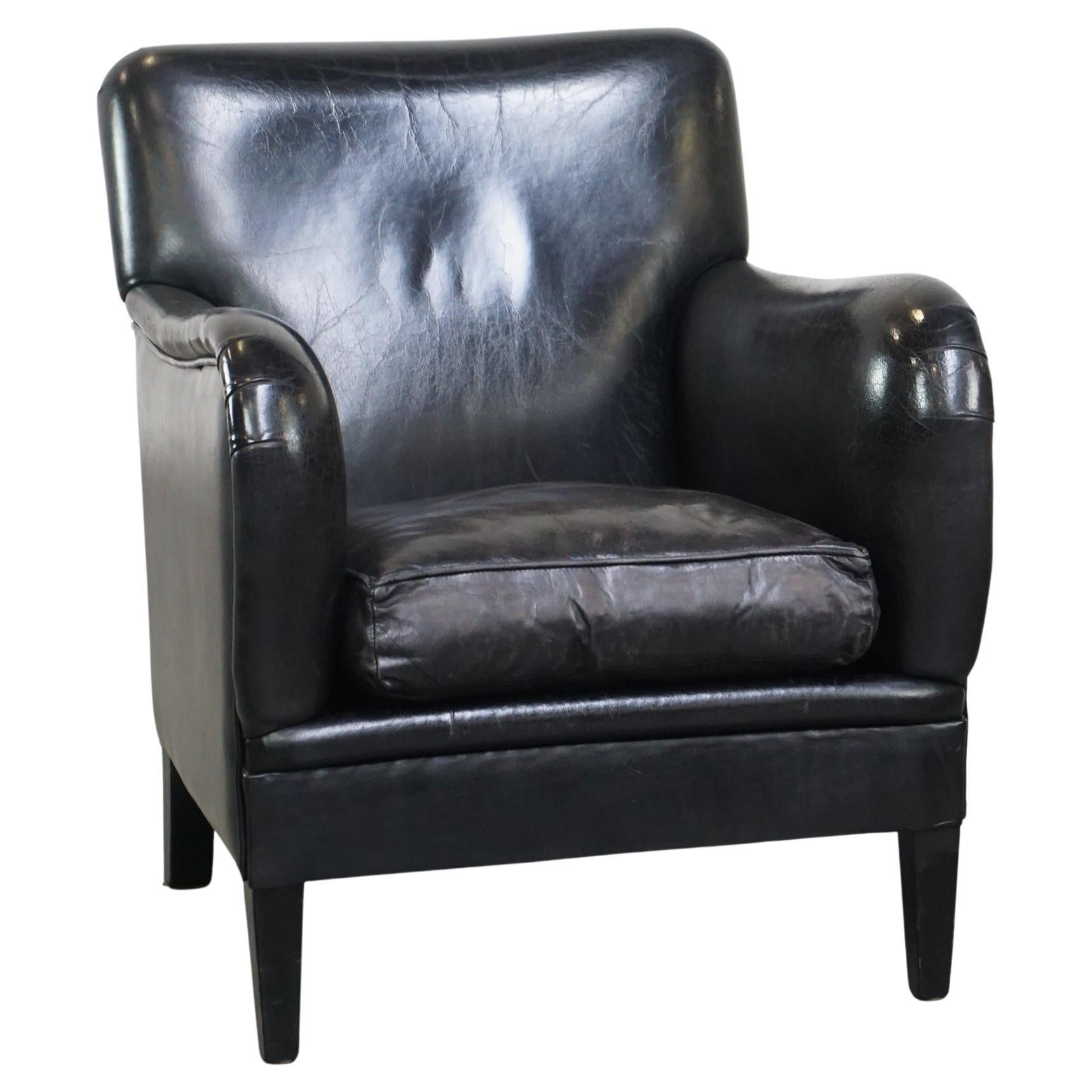 Fauteuil luxueux et confortable en peau de mouton d'une couleur noire unique et majestueuse