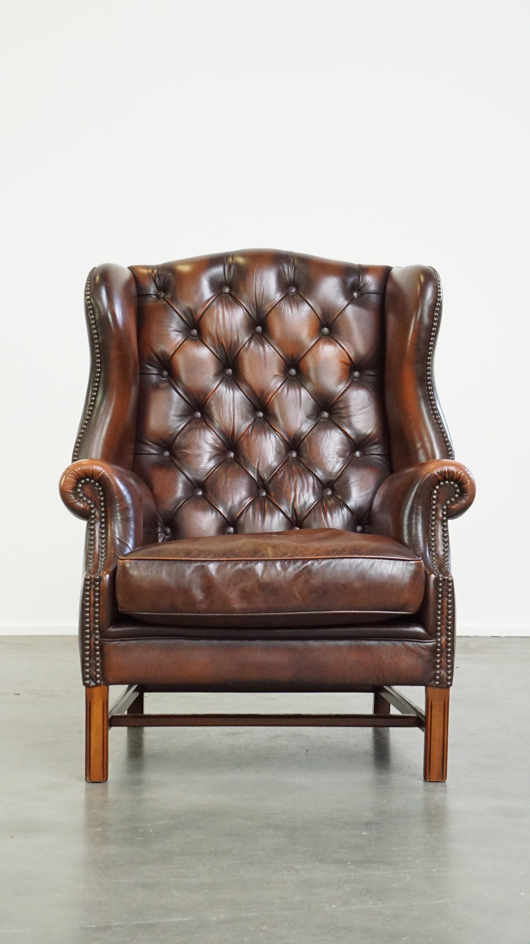 Chesterfield furniture, like this stunning leather armchair, remains beloved and a true eye-catcher in nearly any interior style. With its decorative nail detailing and rich brown color, it radiates luxury and a sense of stately comfort. This