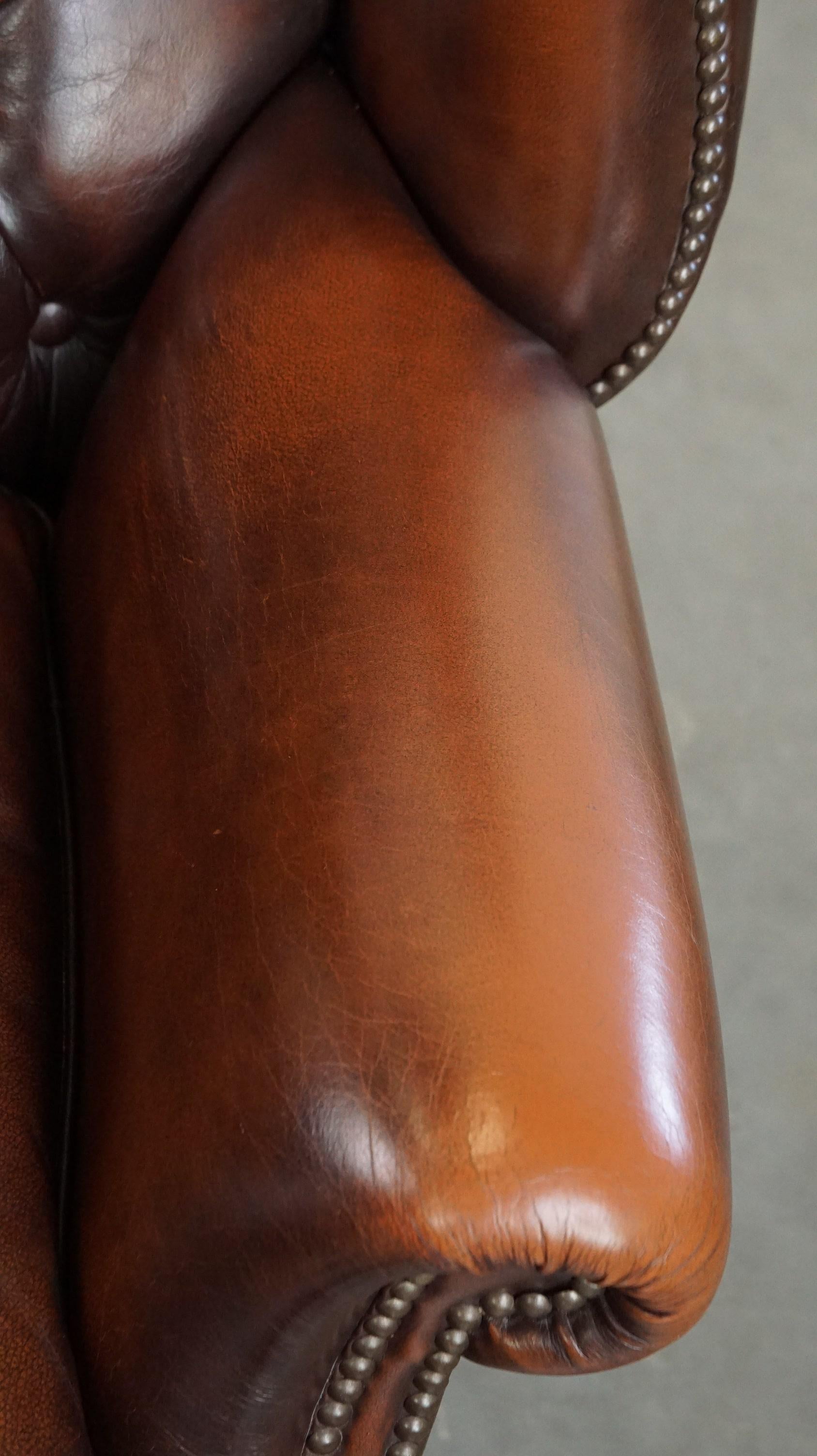 Cowhide Luxurious brown leather chesterfield armchair finished with decorative nails For Sale