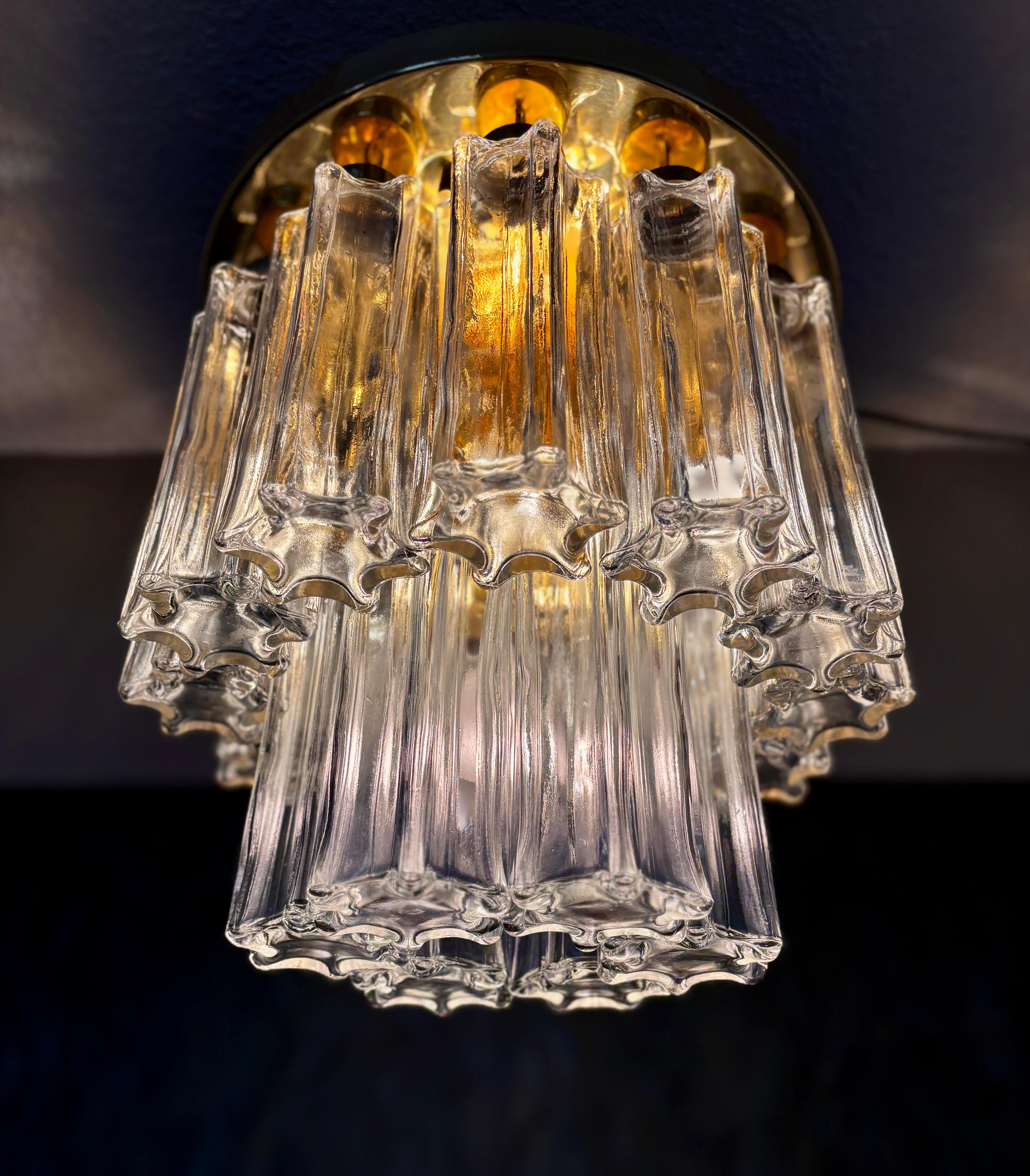 Impresionante lámpara de araña de gran tamaño, muy pesada, diseñada por Helena Tynell y fabricada por Glashütte Limburg en Alemania en la década de 1970. Una lámpara de techo glamurosa y lujosa, con un diseño de dos niveles y una base de latón
