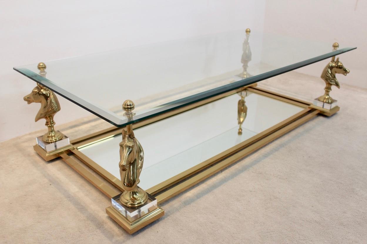 This gorgeous and elegant ‘Cheval’ coffee table originates from France and was manufactured in the 1970s by Maison Charles. The table features a two-tiered brass frame. The lower glass tier features clear mirrored-glass, the top glass tier is made