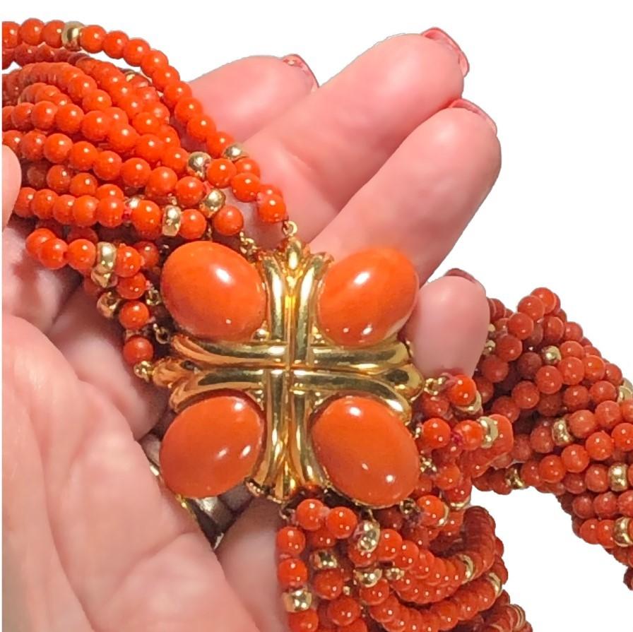 This magnificent mid-20th century front closing choker length torsade necklace, has, as the focal point in the front, a beautifully articulated 18k gold plate set with four large orange coral cabochons. The clasp alone measures 1  5/8inches long by