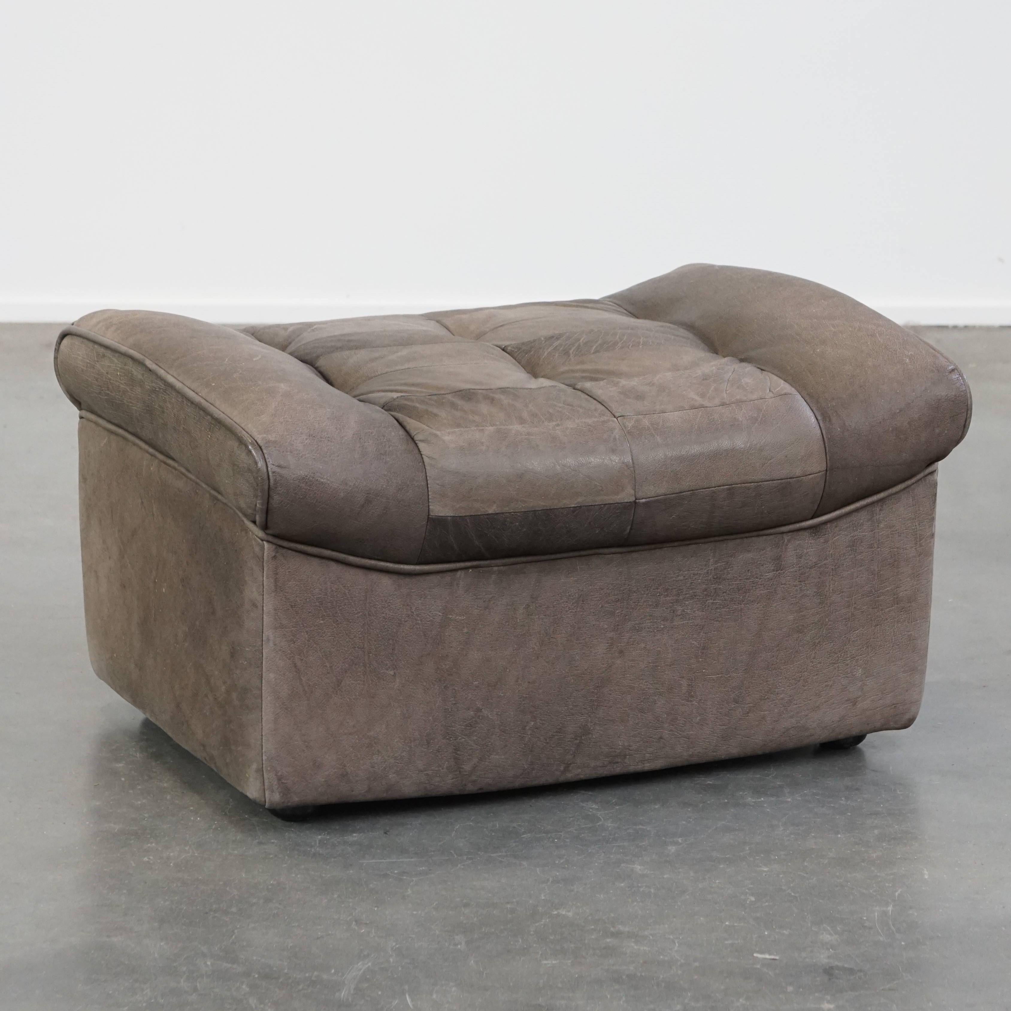 Offered this luxurious, comfortable, grey leather vintage footstool.

A leather footstool, also called a footstool, turns your already comfortable armchair into a true relaxation paradise. With your feet resting on this footstool, you can enjoy your