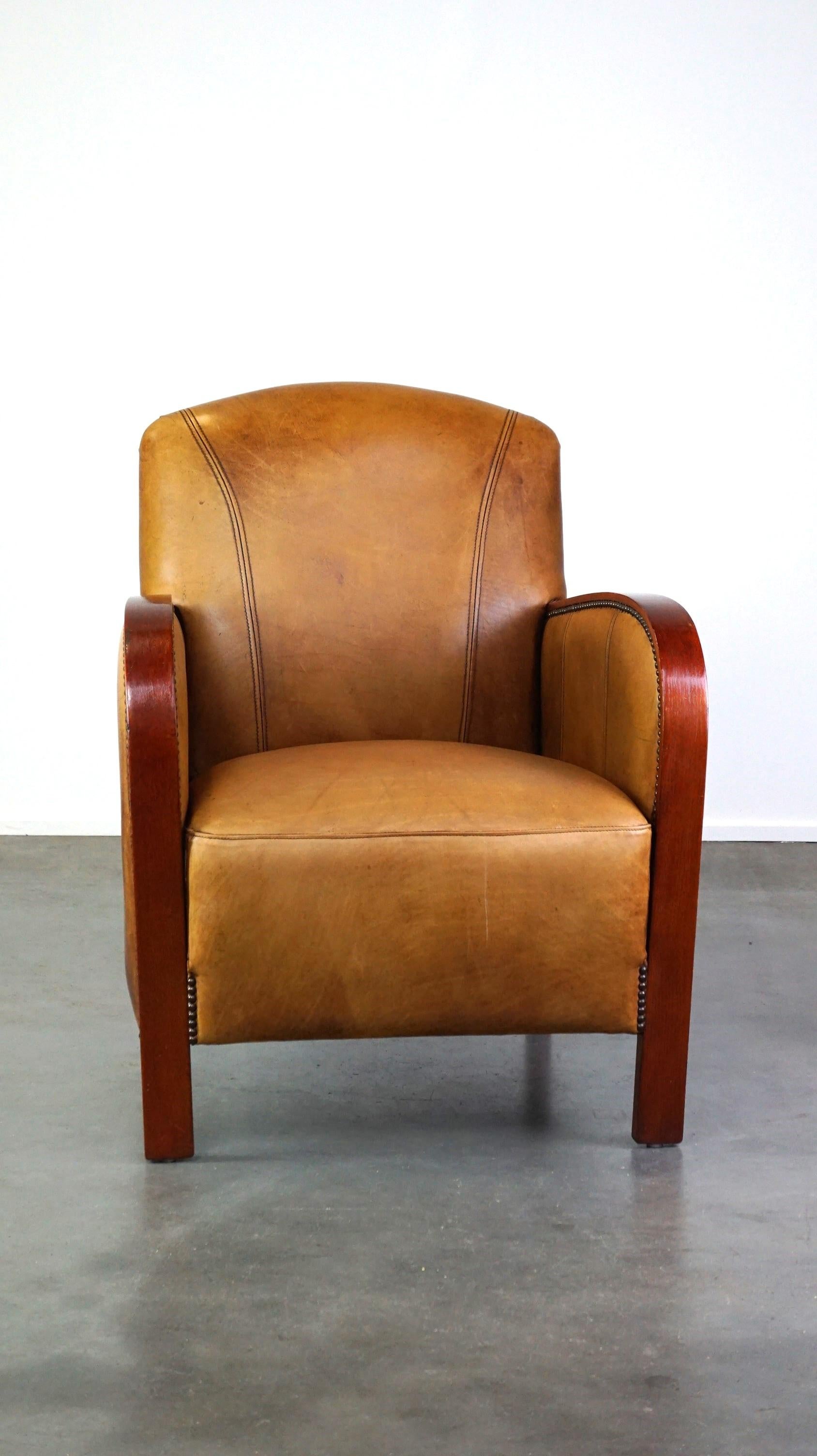 Offert ce luxueux fauteuil Artdeco en cuir de vachette avec accoudoirs en bois et cuir de couleur cognac.

Ce magnifique fauteuil a une apparence luxueuse grâce à son design et à ses détails. Il peut donc facilement trouver sa place dans un