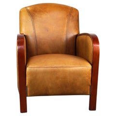 Luxurious cowhide Art Deco design armchair with wooden armrests