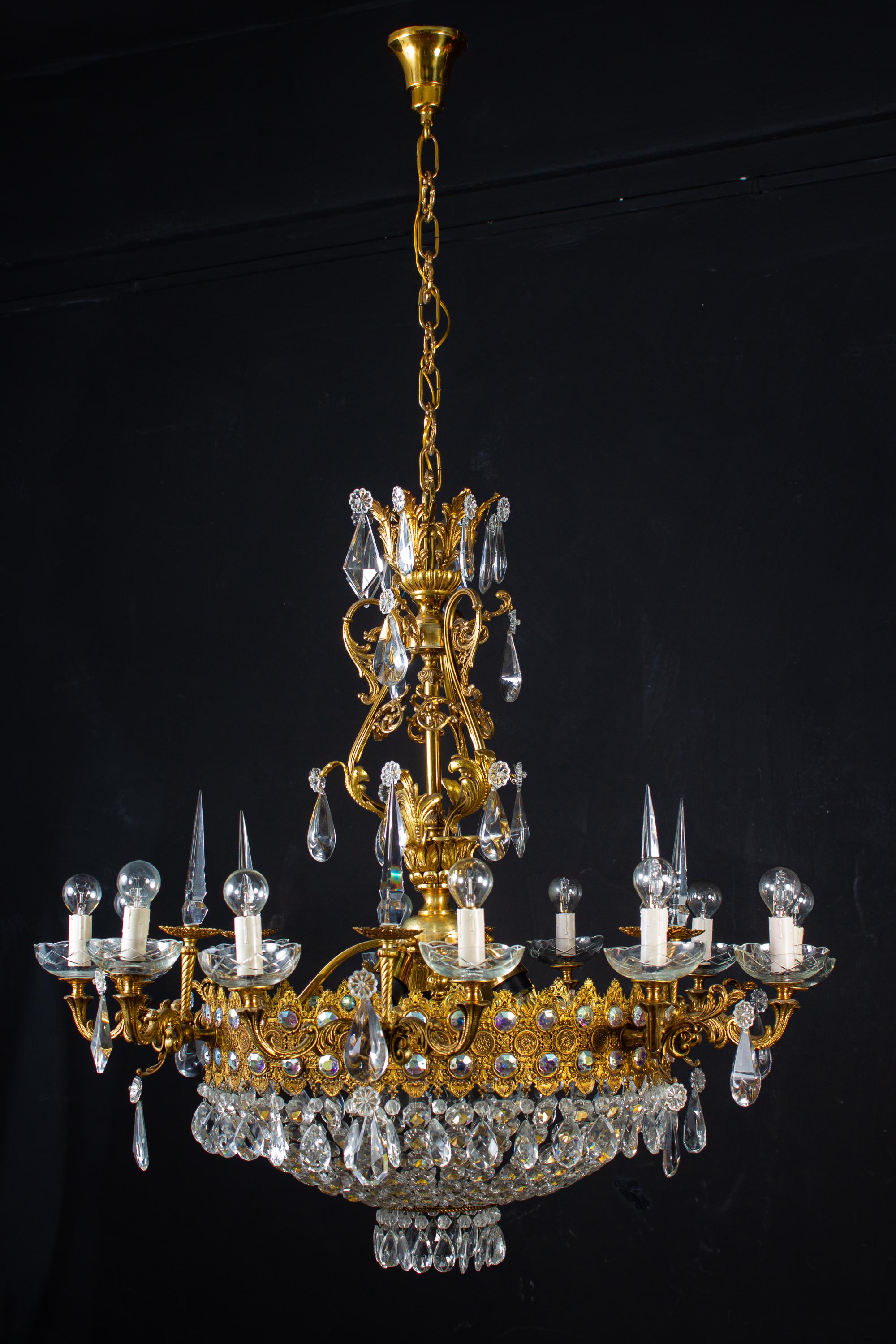 This Sumptuous twelve arms chandelier with a set of precious diamond shape cut crystal and drops on a finely chiseled gilt bronze support, decorated with Acanthus leaves. Matching bronze gilded chain and a ceiling canopy.
Ideal for a large