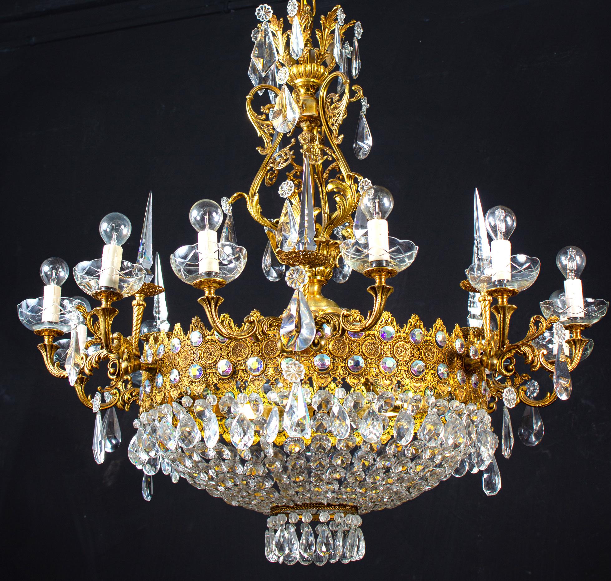 This Sumptuous twelve arms chandelier with a set of precious diamond shape cut crystal and drops on a finely chiseled gilt bronze support, decorated with Acanthus leaves. Matching bronze gilded chain and a ceiling canopy.
Ideal for a large reception