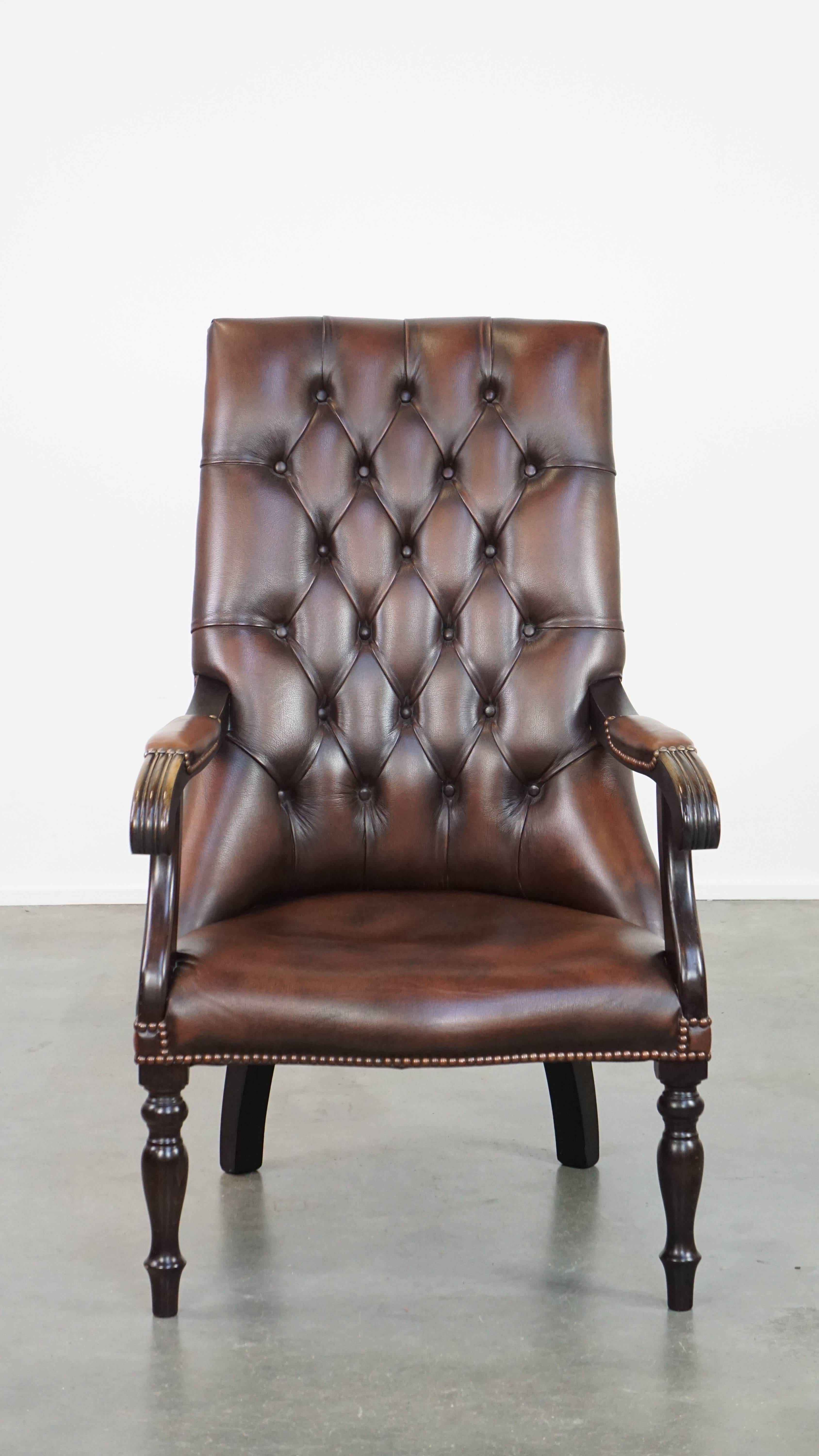 This fantastic chesterfield armchair is the perfect representation of English class and comfort. Made from cowhide leather and complemented with wood, its elegant front legs and precise finish with decorative studs add that extra touch of