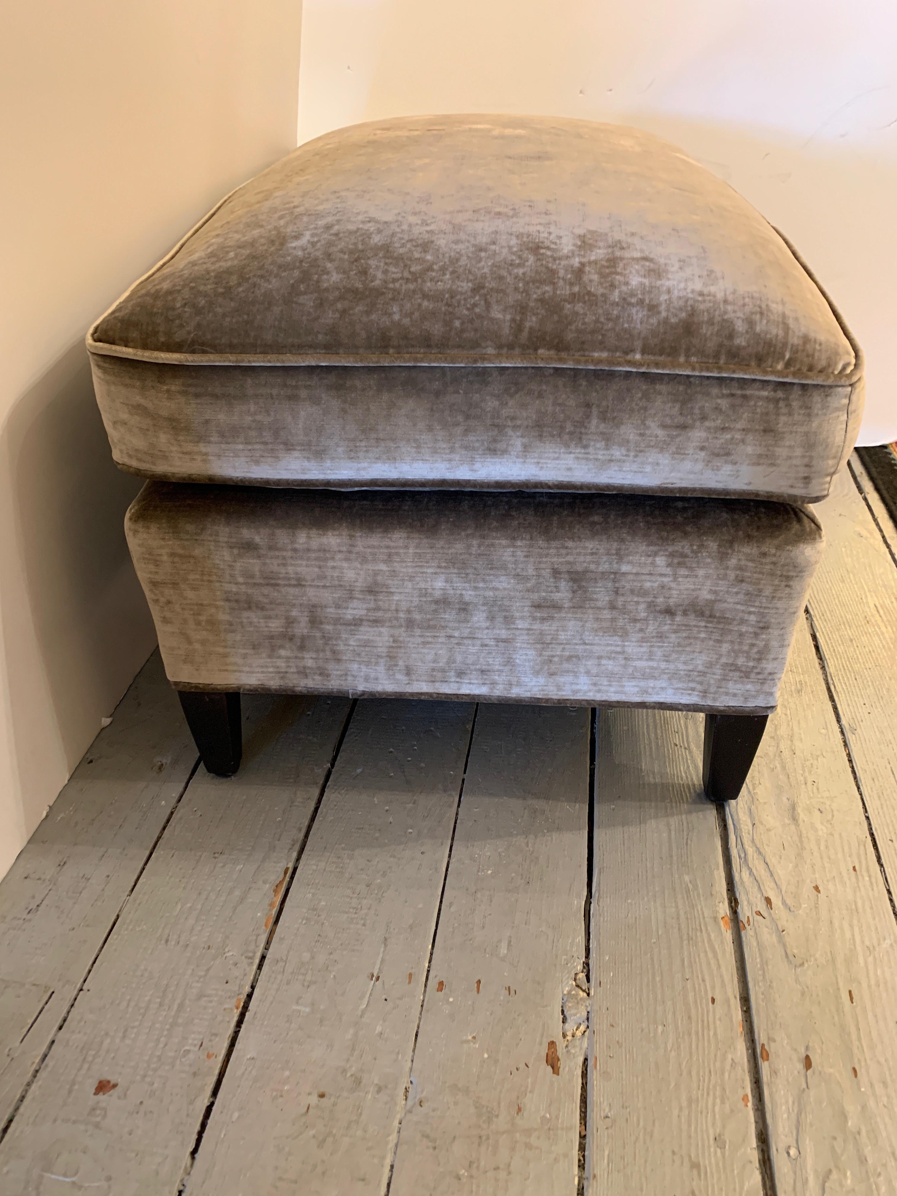 Top of the line custom ottoman upholstered in soft gray mohair velvet with ebonized feet.