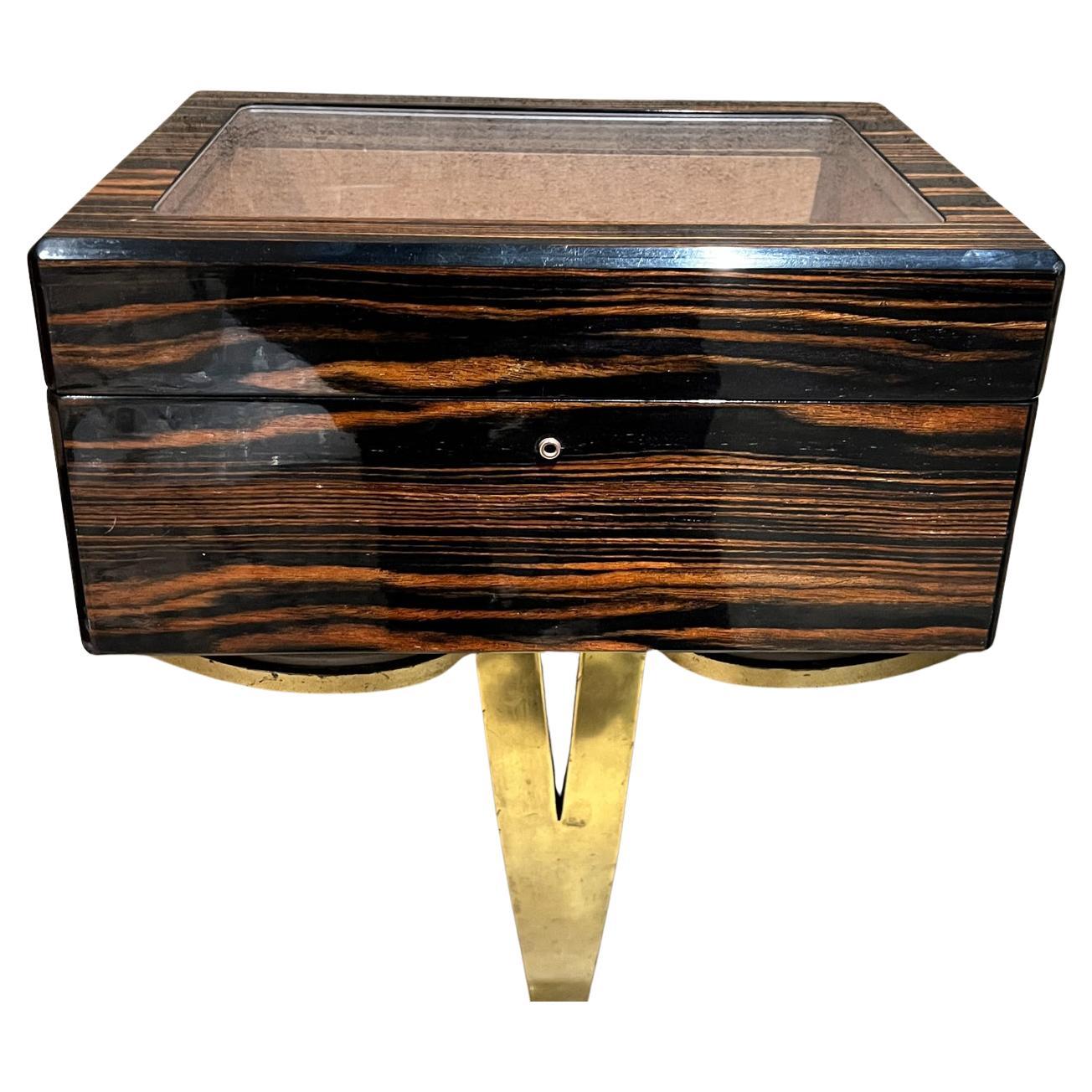 Exotic Macassar wood Cigar box brass handles glass cover.
7.75 h x 18 w with handle box 16. X 11.25 d
No label- attributed style of Dunhill
Preowned original vintage
Refer to listed images