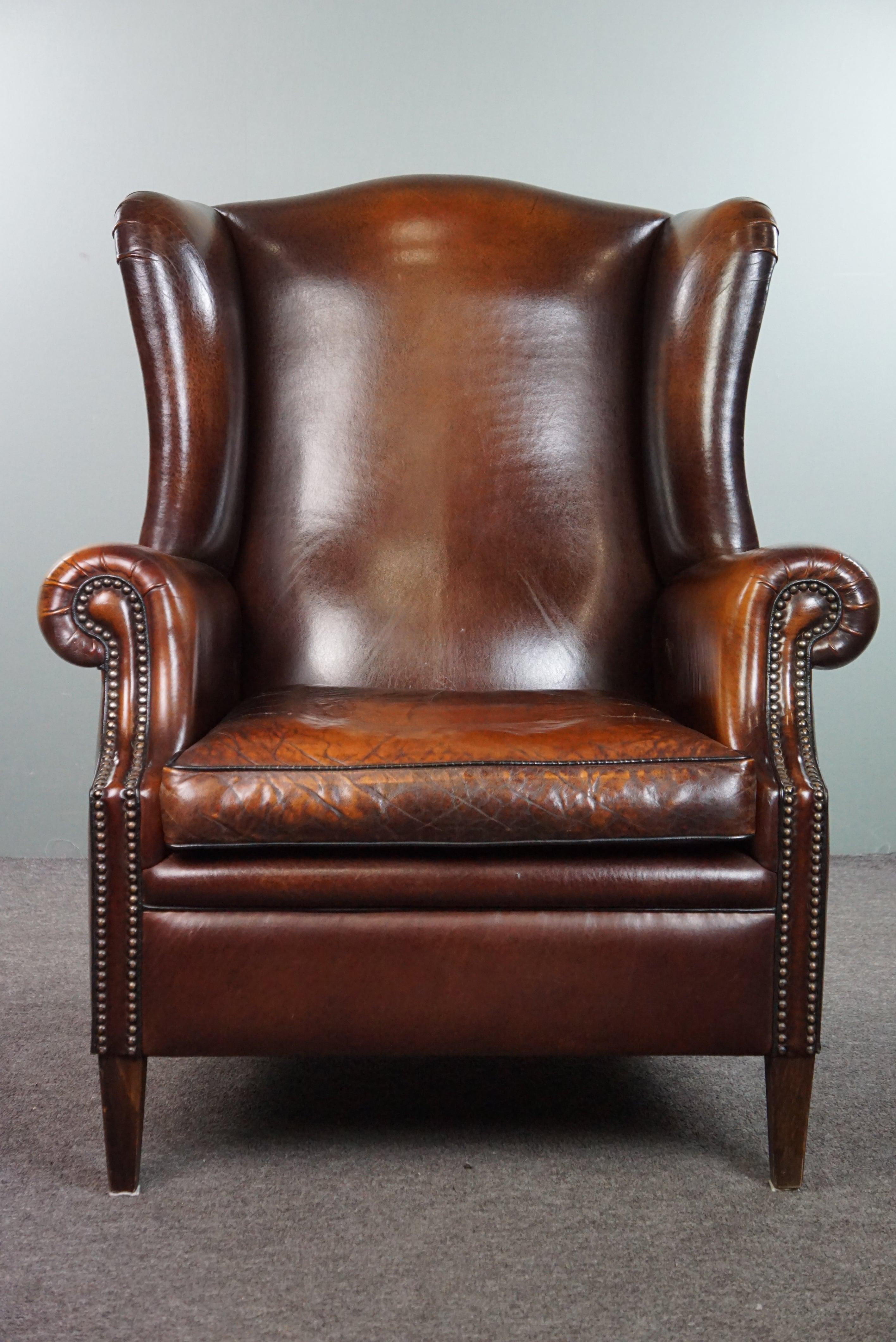 Offered is this beautiful and luxurious large sheep leather wingback armchair with stunning colors and amazing patina finished with decorative nail heads. 

For those seeking a comfortable sheep leather wingback armchair with a fantastic appearance,