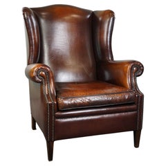 Used Luxurious large sheep leather wingback armchair with beautiful colors and patina