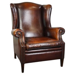 Luxueux fauteuil à oreilles en cuir de mouton de grande taille avec de belles couleurs et patines.