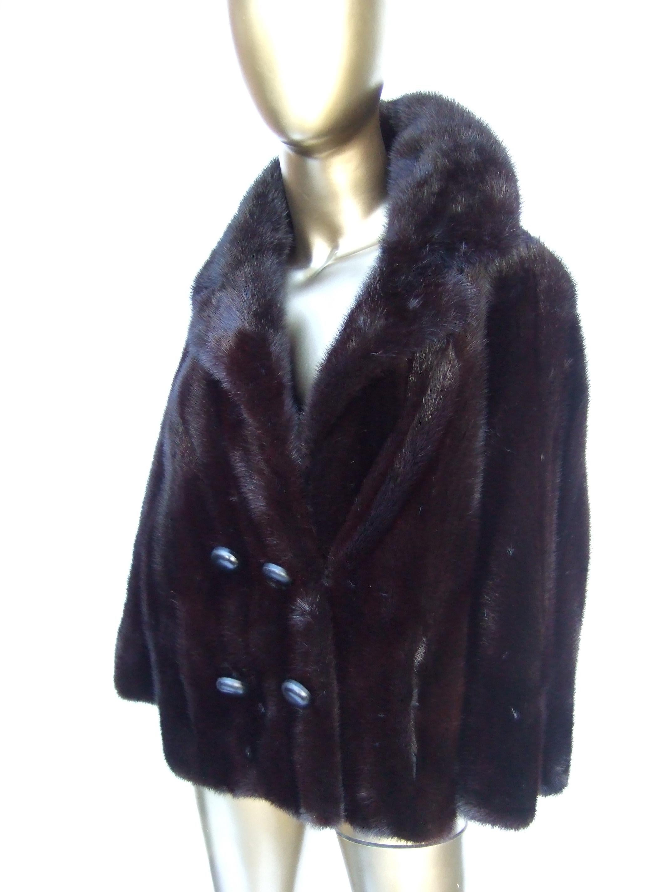Luxurious mahogany plush dark brown mink fur jacket by Bill Marre' c 1970s
The stylish vintage jacket is designed with lustrous soft mink fur
Adorned with four decorative stationary buttons on the lower front
Secures closed with a hidden hook
