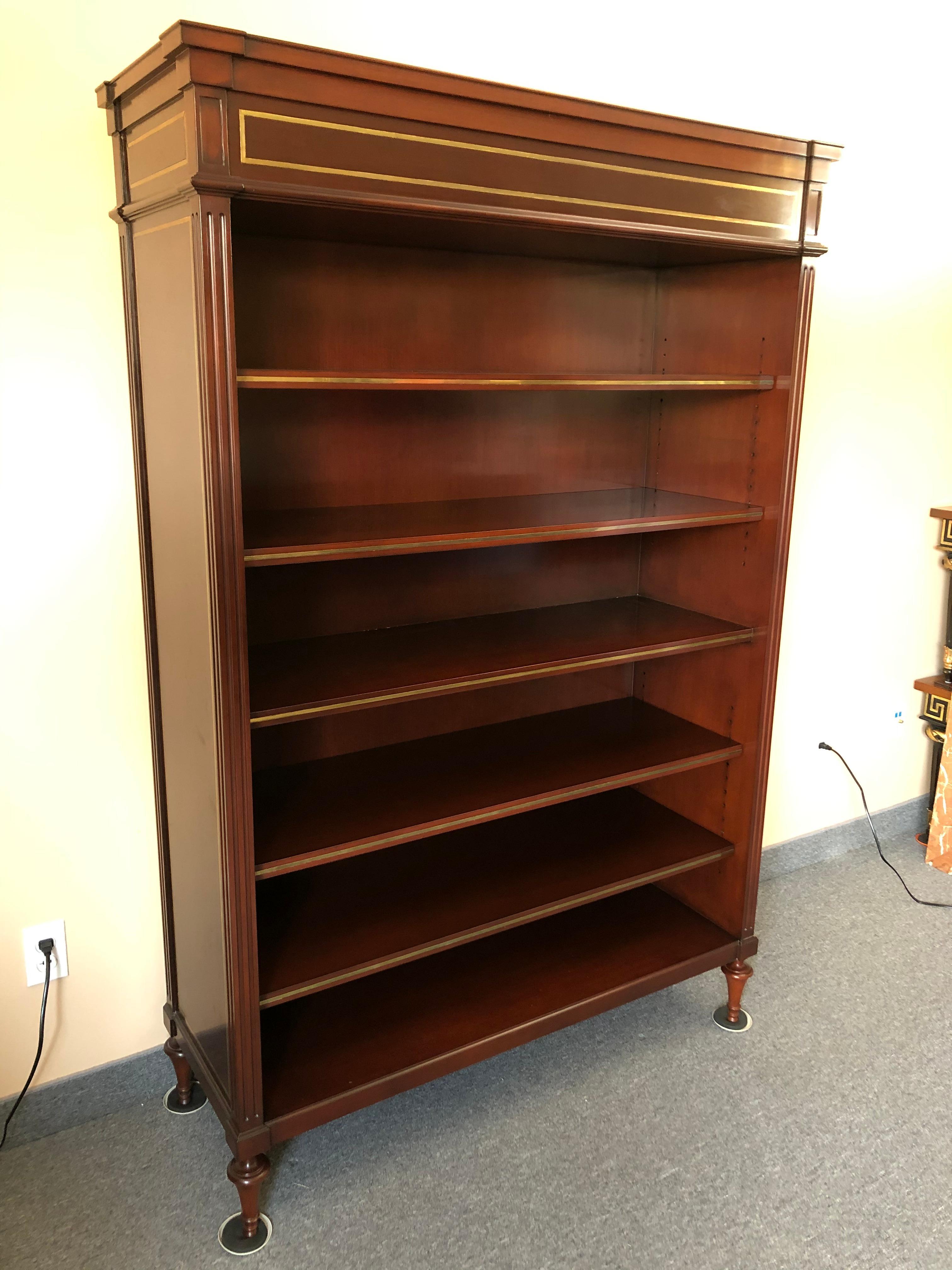 Top of the line designer solid dark mahogany bookcase having adjustable shelves, stunning inlaid brass banding on the body of the bookcase and each shelf, handsome turned feet, and finished back.