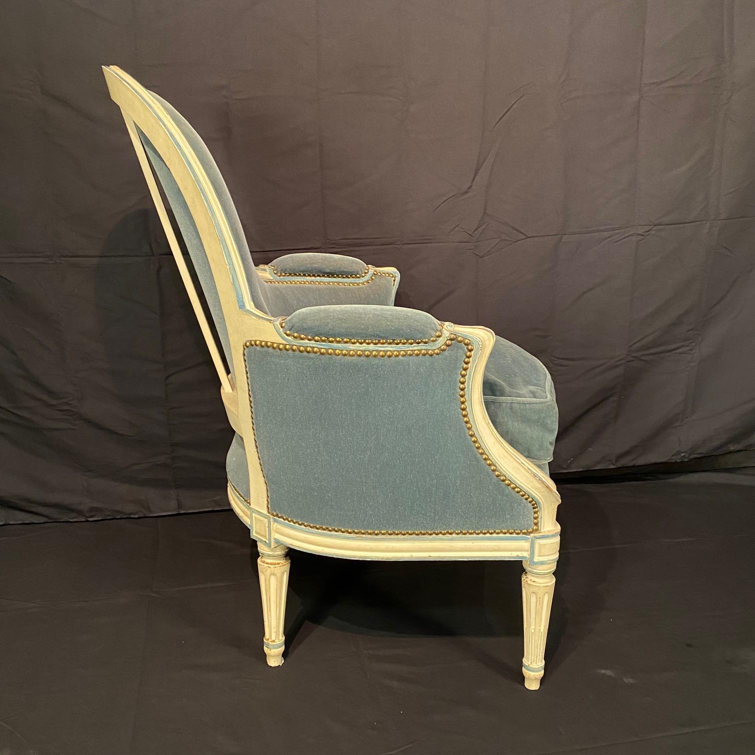 Ancienne peinture et sculpture de style Louis XVI  fauteuils ou chaises bergères,  peinture d'origine et tapisserie en mohair bleu, avec des agrafes en laiton. Créées en France au début du XXe siècle, ces chaises présentent un dossier arrondi,
