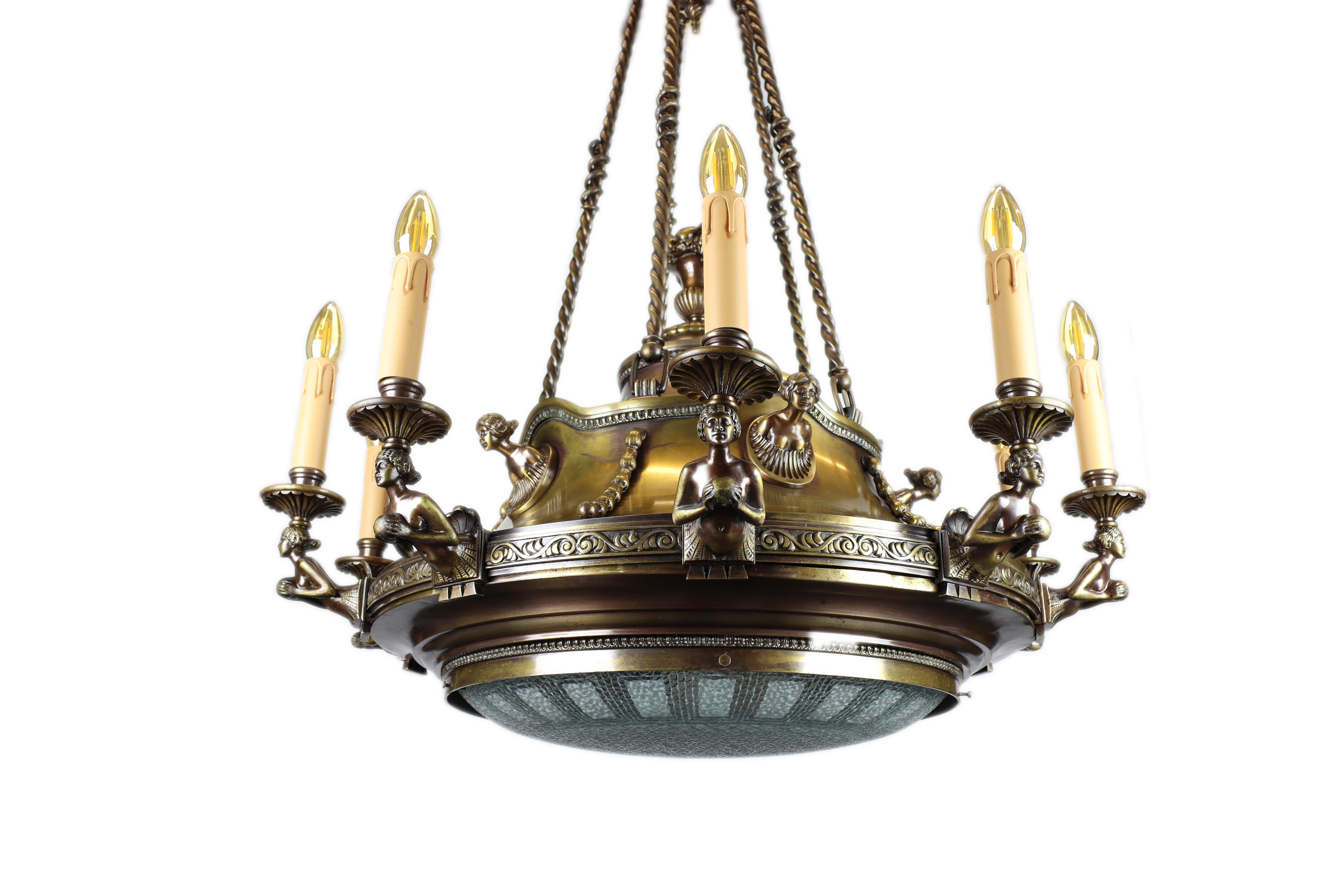 This beautiful representative chandelier from the Art Nouveau period was made around 1918. It is decorated with a beautifully shaped figural depiction of figures, each of the ten carrying one candle around the perimeter. All figural elements are