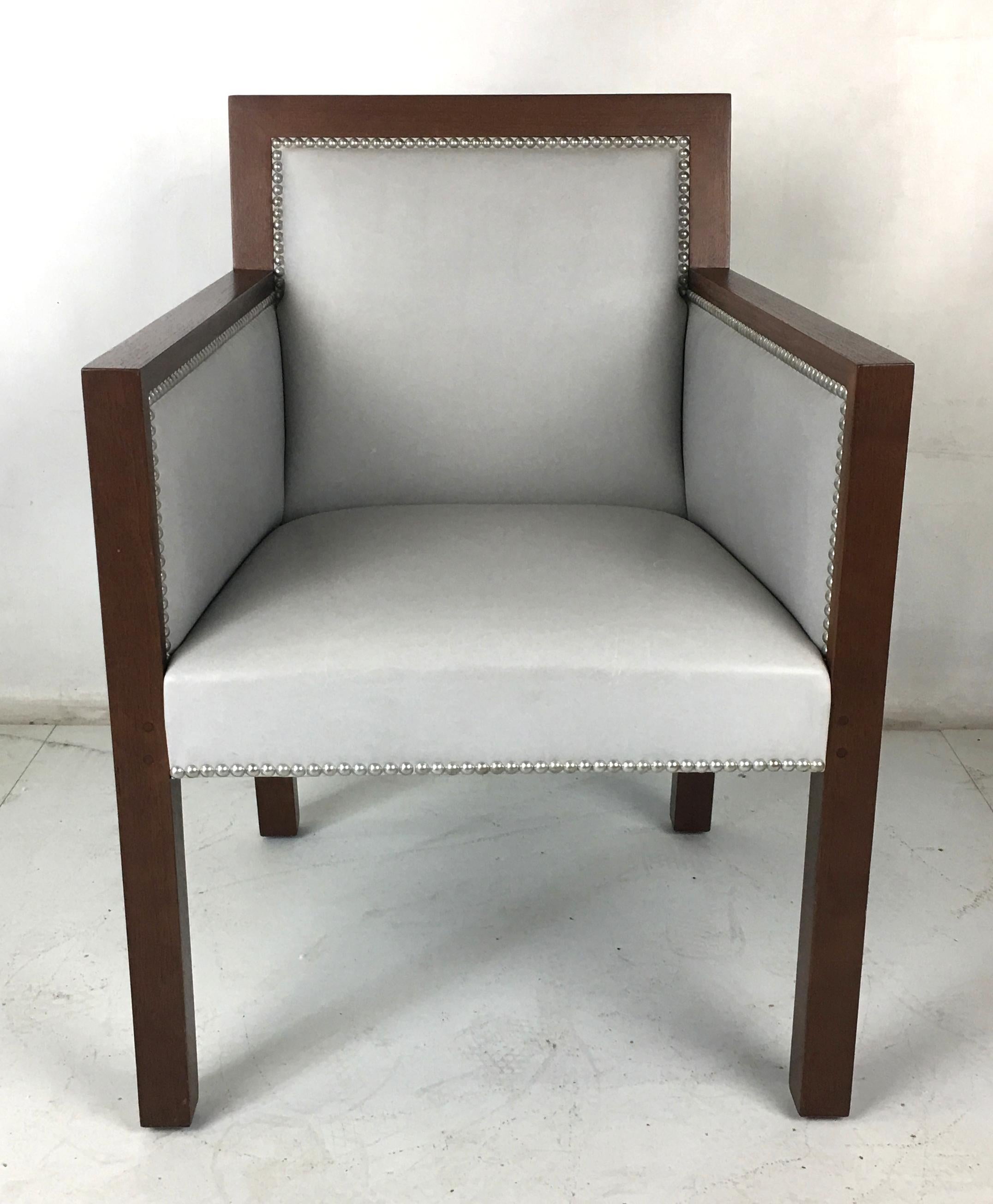 Luxe set of four mahogany and leather dining armchairs by John Hutton for Sutherland. The stout frames are upholstered in light grey glove leather with nickel nailhead trim, which can be kept or replaced with leather trim.