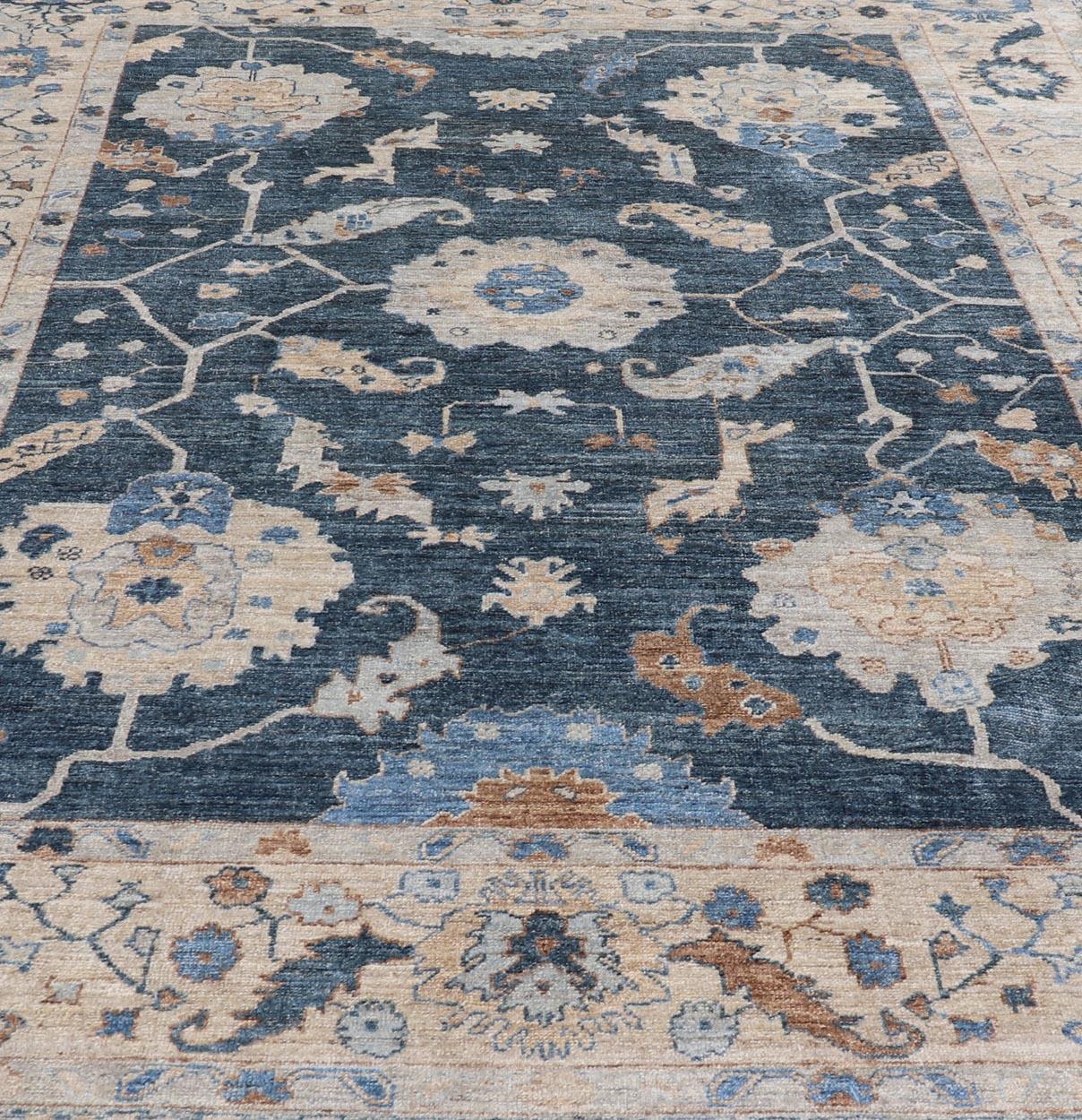 Measures: 10'2 x 14'7 
Elevate your living space with a Reproduction Turkish Angora Oushak Rug, beautifully crafted to bring a sense of luxury and timeless elegance to any room. Featuring a deep blue background, this rug is adorned with intricate