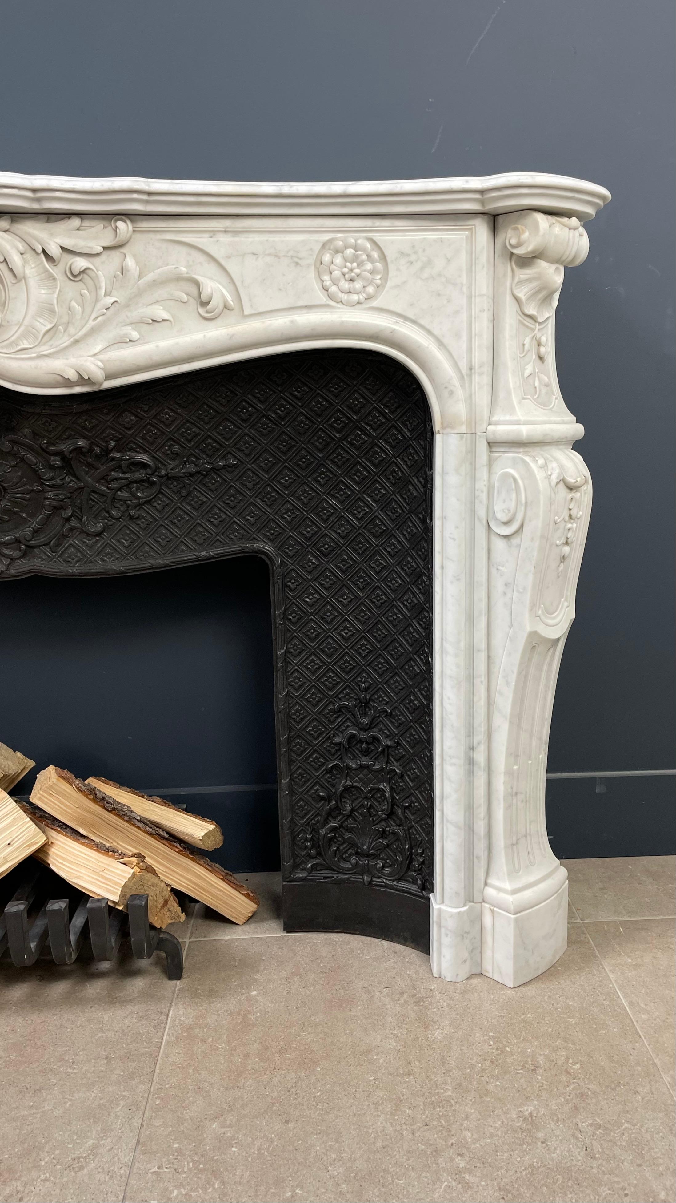Introducing our exquisite French Antique Shell Fireplace, crafted from elegant white Carrara Marble. This luxurious antique fireplace is accompanied by a specially designed cast iron fireplace insert, perfectly tailored to complement its timeless