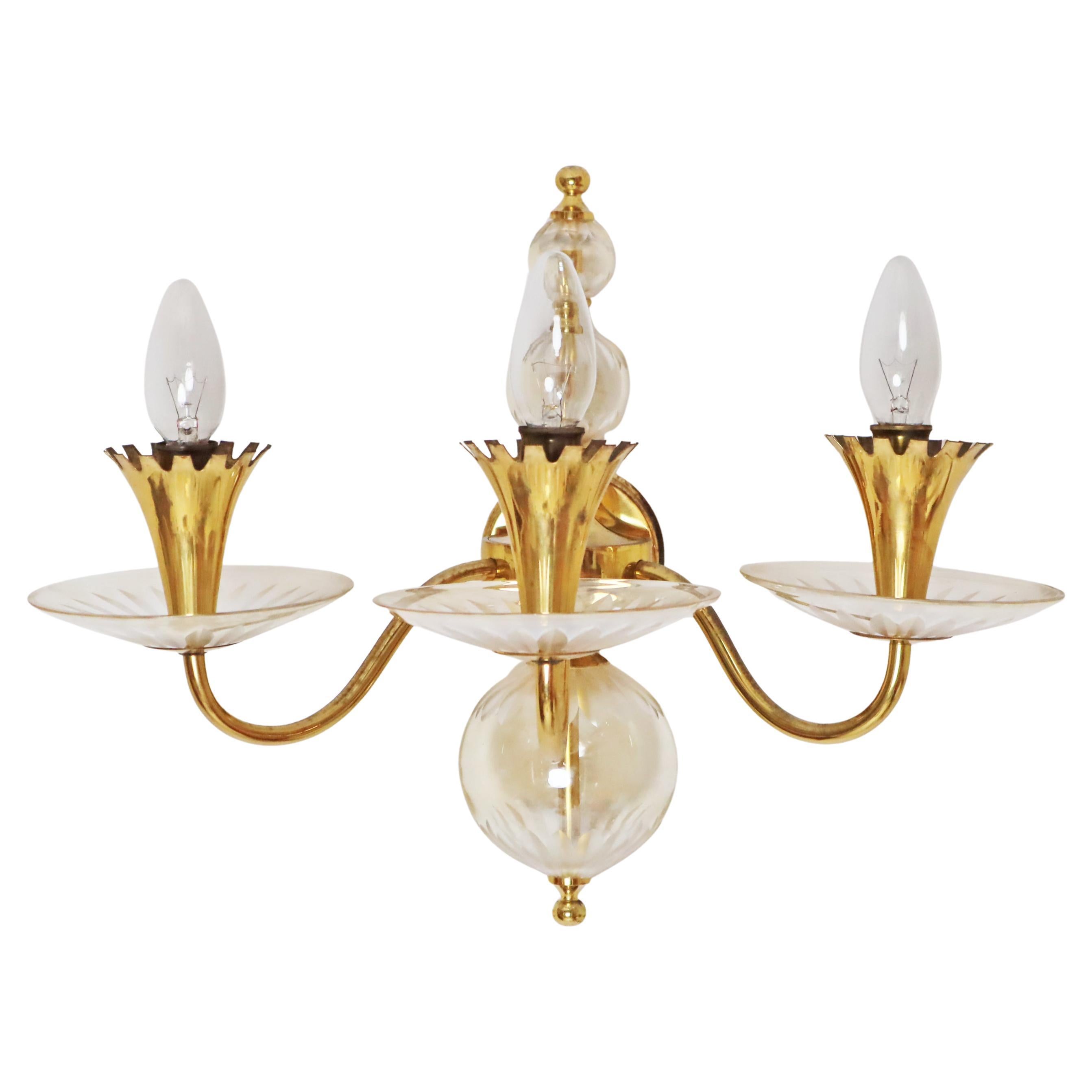 Questa grande applique a tre bracci è semplice ma elegante. Il design di questa applique è eccezionale e la lavorazione del vetro è stata molto curata. Il vetro è stato tagliato da maestri artigiani e i globi sono soffiati a bocca. Le decorazioni in