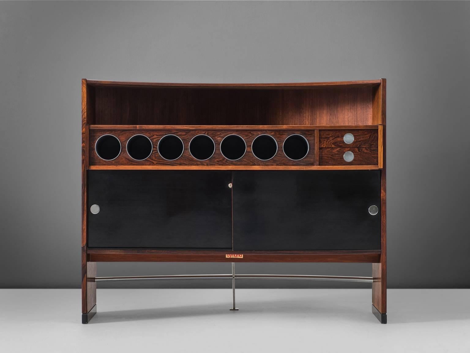 Dry bar, rosewood, chrome, Denmark, circa 1960.

Designed in the 1960s and covered with rosewood veneer. Doors are made from black laminated panels as well as both top decks. Finished with some chrome details which provides a luxury feeling.