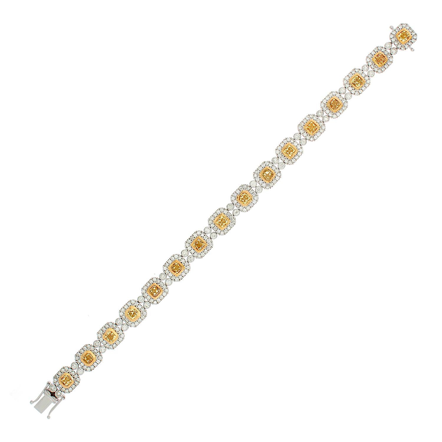A captivating bracelet featuring 5.23 carats of fancy yellow diamonds bezel set in 18K yellow gold. Each cushion cut fancy yellow diamond is haloed and linked by 4.62 carats of round cut sparkling white diamonds set in 18K white gold.  This is a