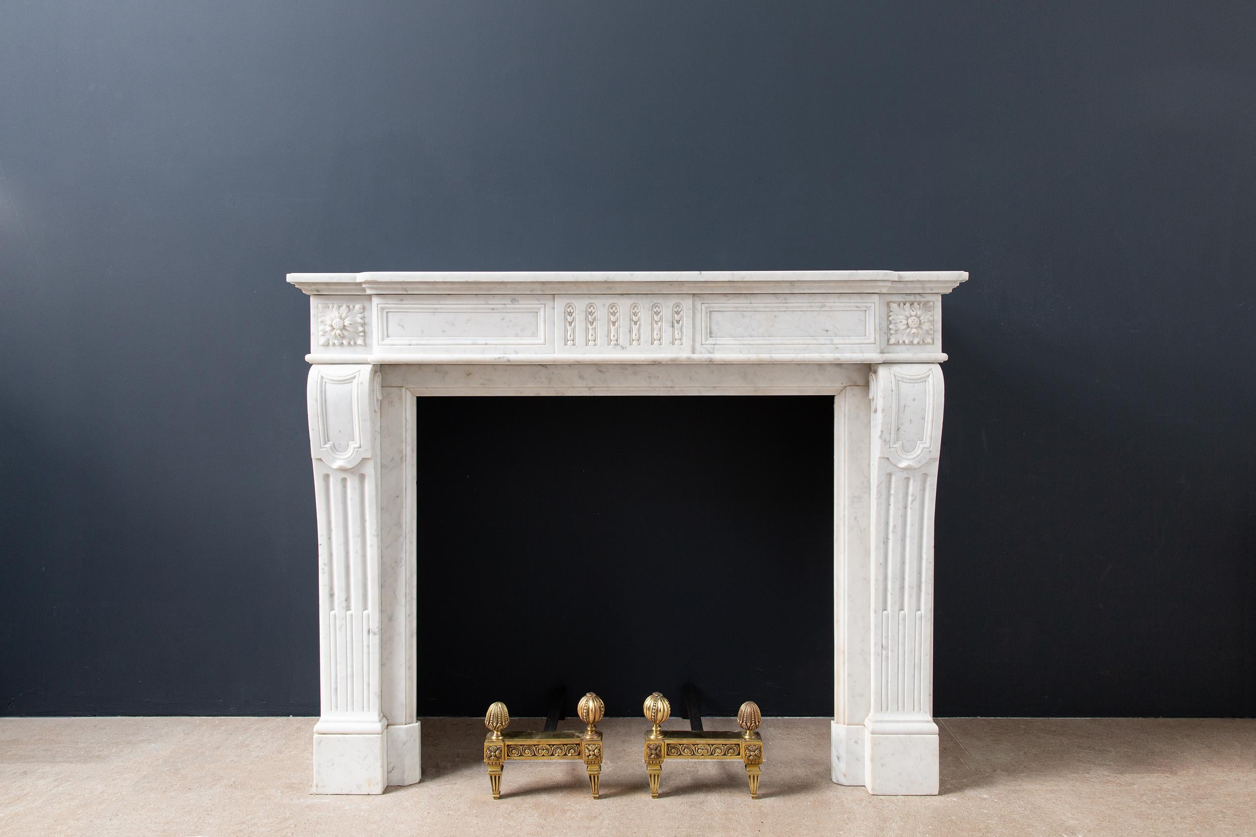 A beautiful French antique fireplace in Louis XIV style, made of Carrara marble. A beautiful and elegant antique fireplace that has a luxurious appearance due to its slim lines and beautiful profile. The difference in depth in the front makes this